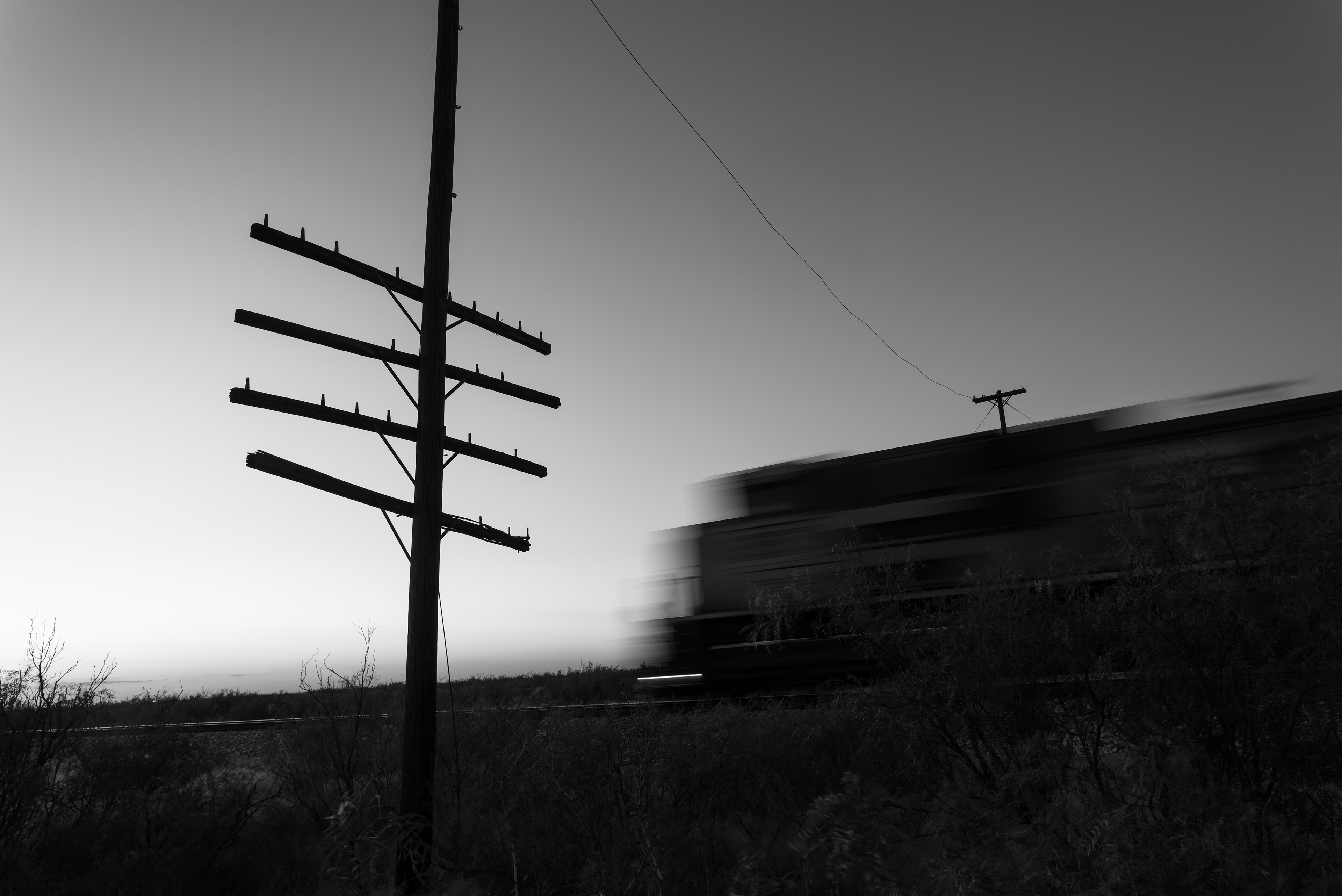 A westbound Union Pacific manifest freight rolls past a lone code line pole out on the Chihuahuan Desert near Pyote, Texas on the old T&P mainline.