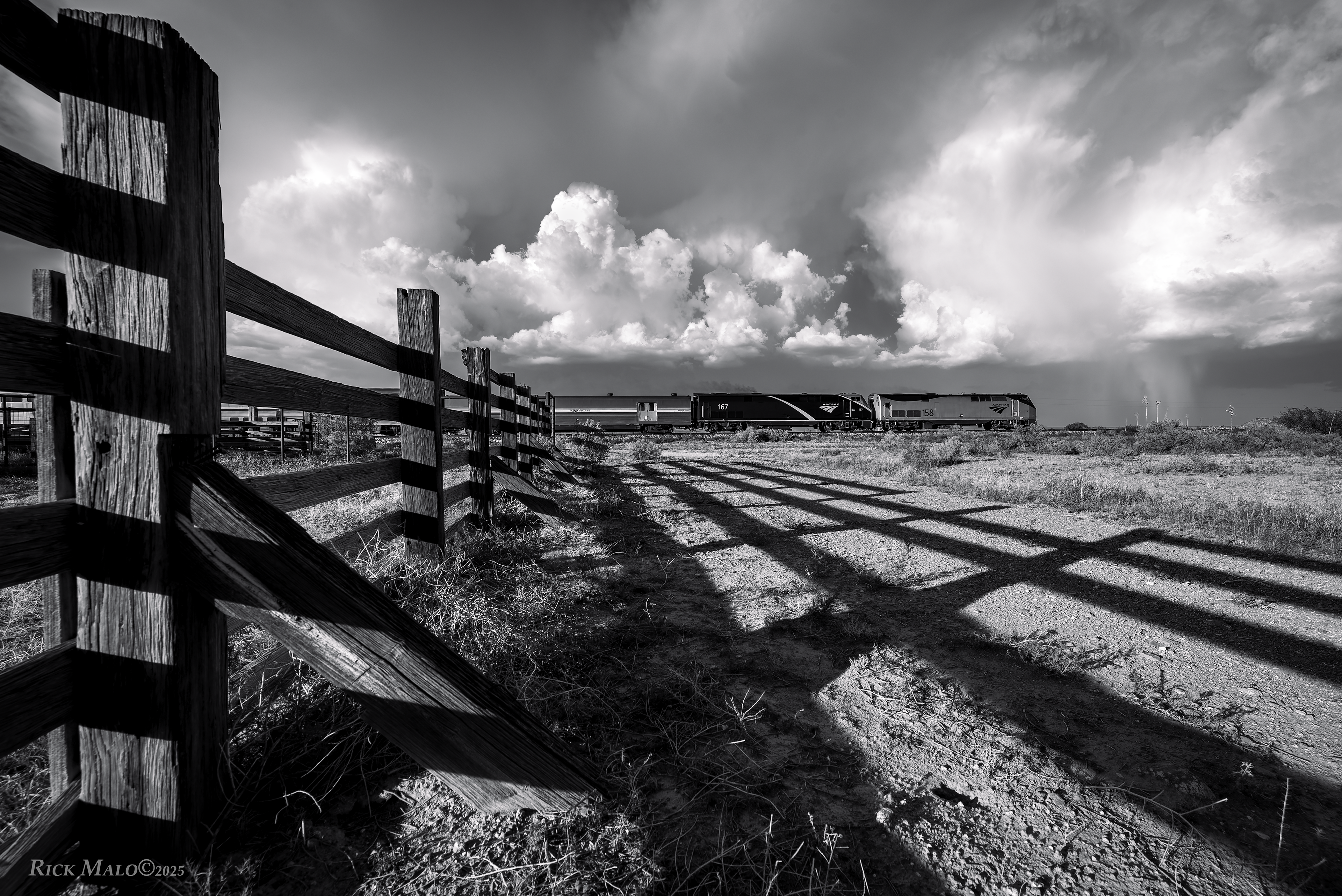 A Summer 2024 afternoon sees a massive thunderstorm pounding the Marfa Plateau as the eastbound Sunset Limited rolls past the old cattle pens at Ryan, Texas.