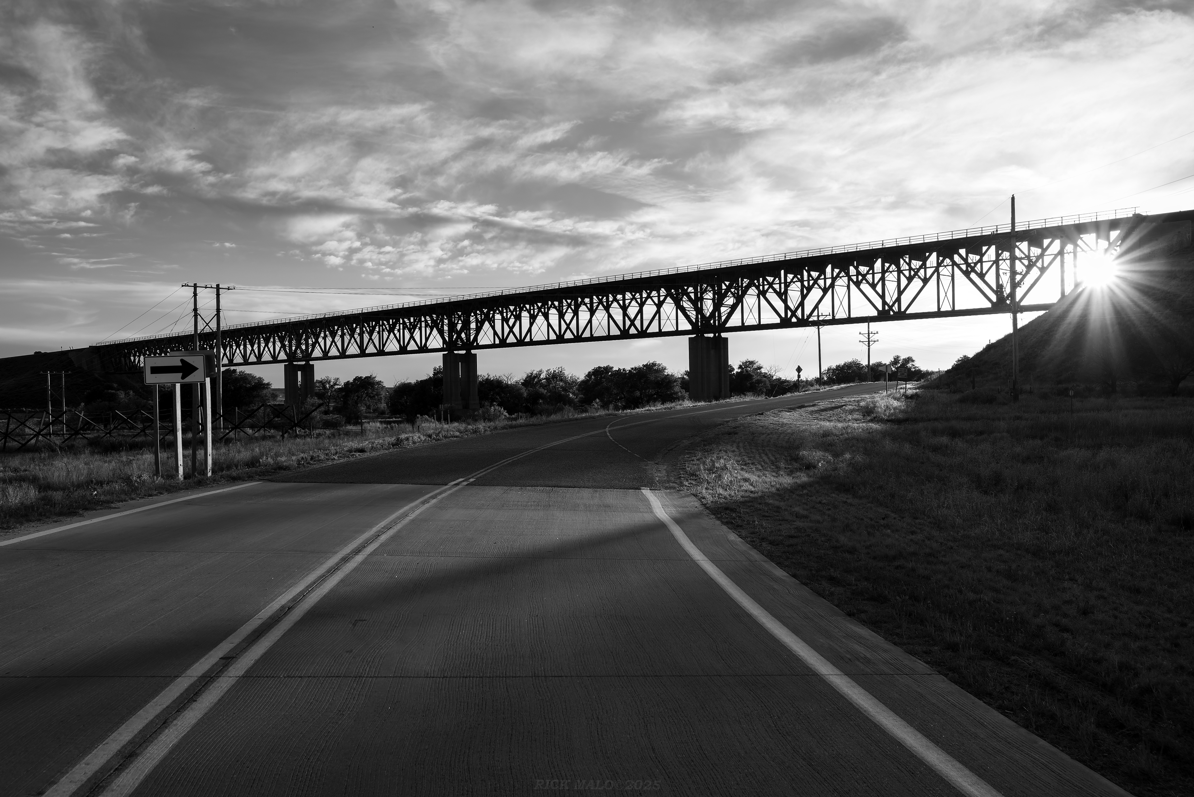 A beautiful Summer 2025 evening finds all is quiet on the Golden State Route as the sun sets behind the Samson of the Cimarron bridge over the Cimarron River east of Liberal, Kansas