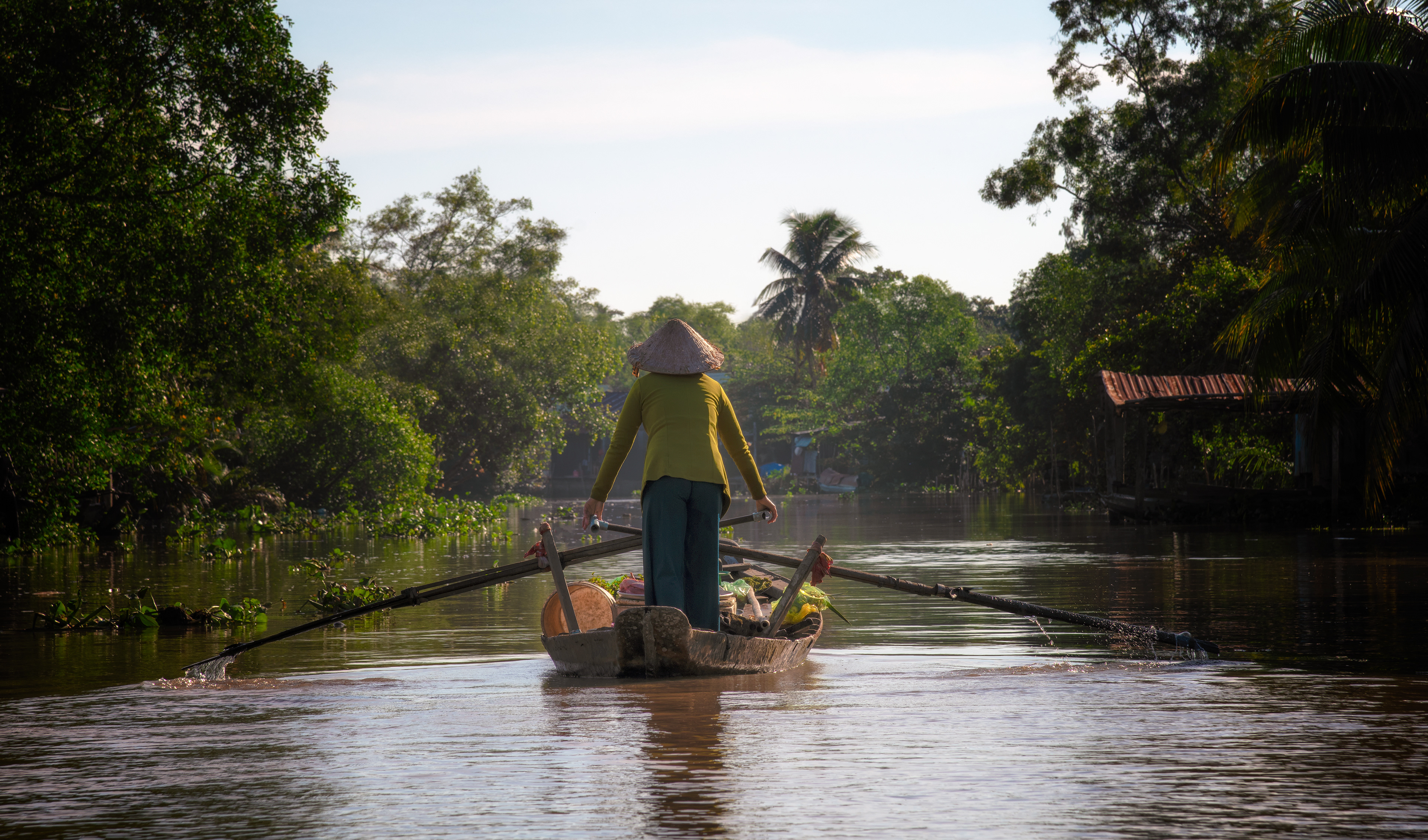 A canal in the Mekong Delta, the trees along it thick with fragrant flowers — the alligator man idling well back so I could shoot this on a longer lens without breaking the quiet of it. One of my favorites from the trip — not for anything technical, just the calm of the whole place.