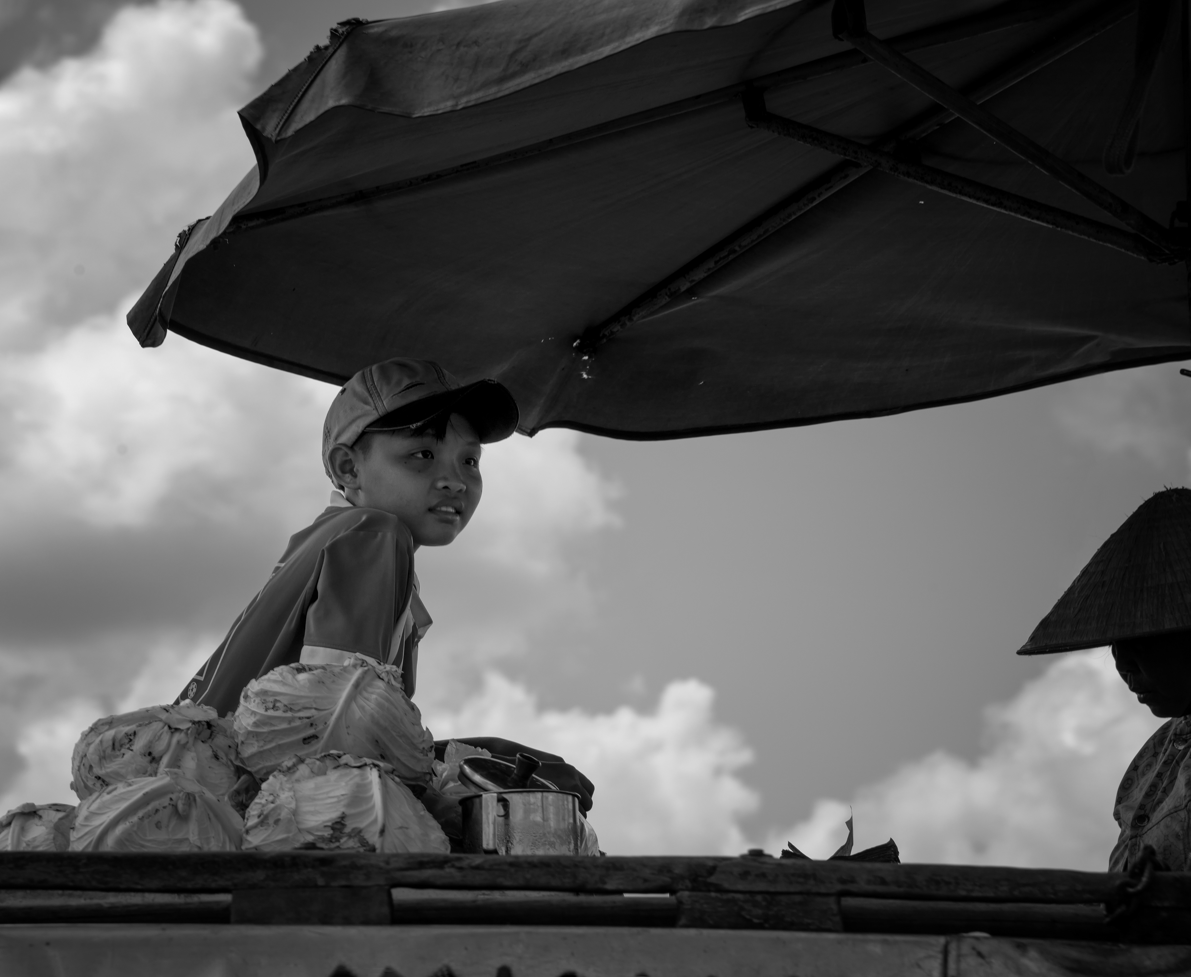 Cai Rang floating market, Mekong Delta — not the world's largest, as it turns out, though it might as well have been from where this boy sat. He looked like he was having the time of his life, perched among the cabbages, taking it all in.
