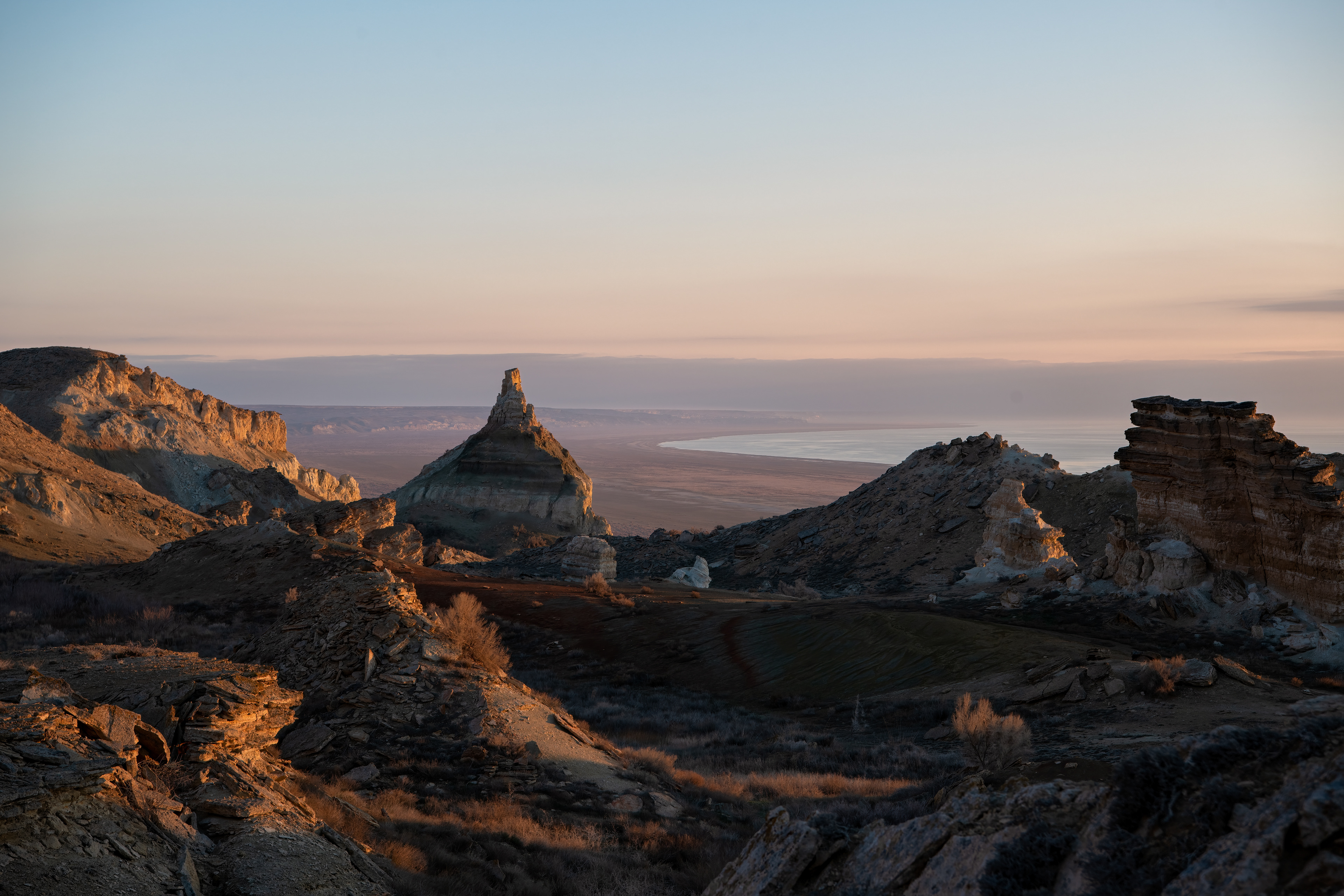 The Ustyurt Plateau. We stayed the night in a yurt camp perched on its edge, the cold cutting through everything — ground that's carried people since Neolithic fishing settlements, six or seven thousand years back, long before there was a sea here to lose.
