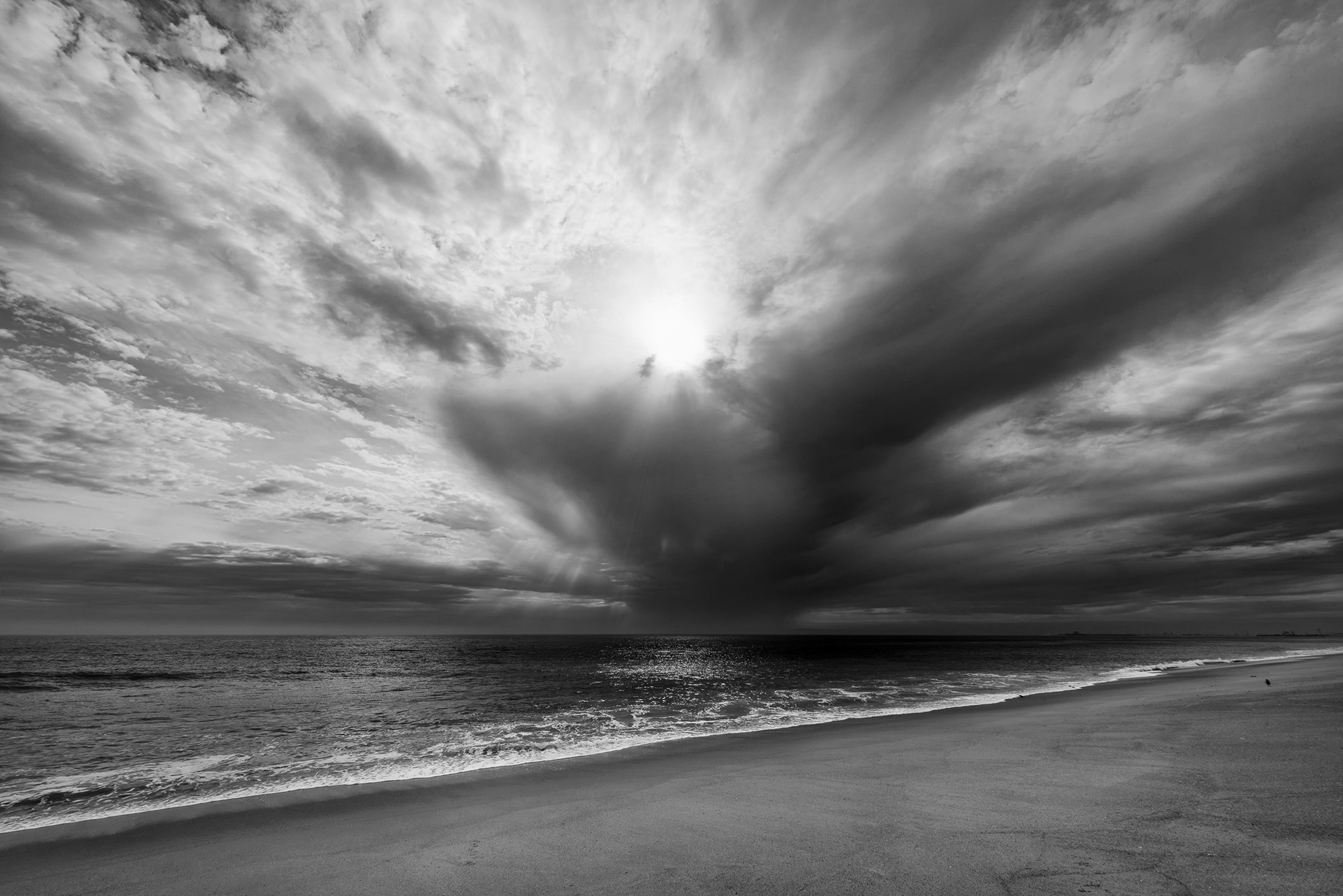 A storm cell off the Southern California coast — genuinely rare here. Thunderstorms need moisture, instability, and lift, all three, at the same time, and this coastline can usually only manage one or two. September is the one dependable window, when the tail end of the North American monsoon drags tropical moisture up from Mexico and the ocean, for once, stops being the thing that shuts the whole process down. Black and white, because the storm did the composition's work on its own.