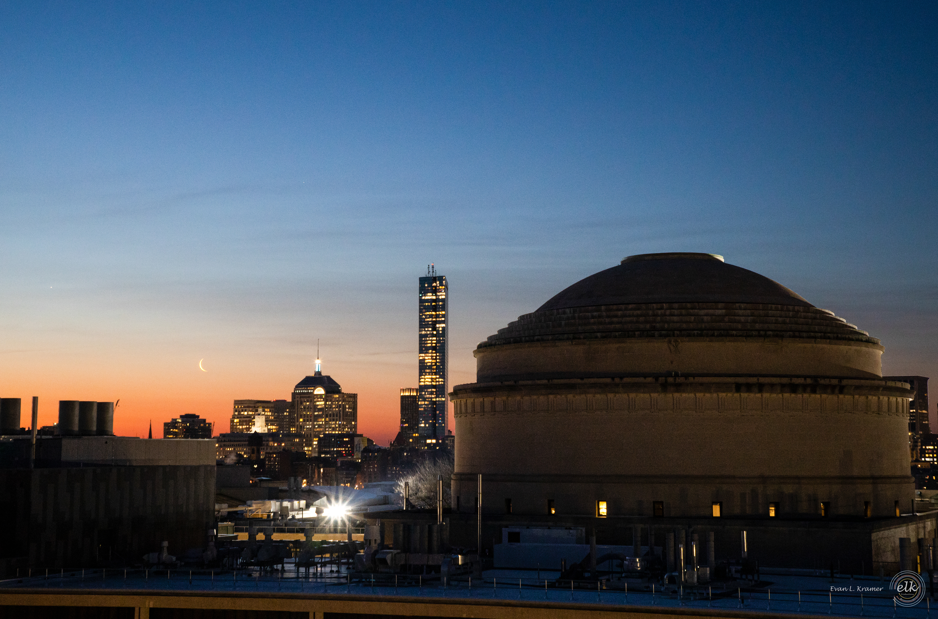 The MIT Dome and Boston skyline with a crescent moon, Jupiter, and Saturn at sunrise. Cambridge, MA.