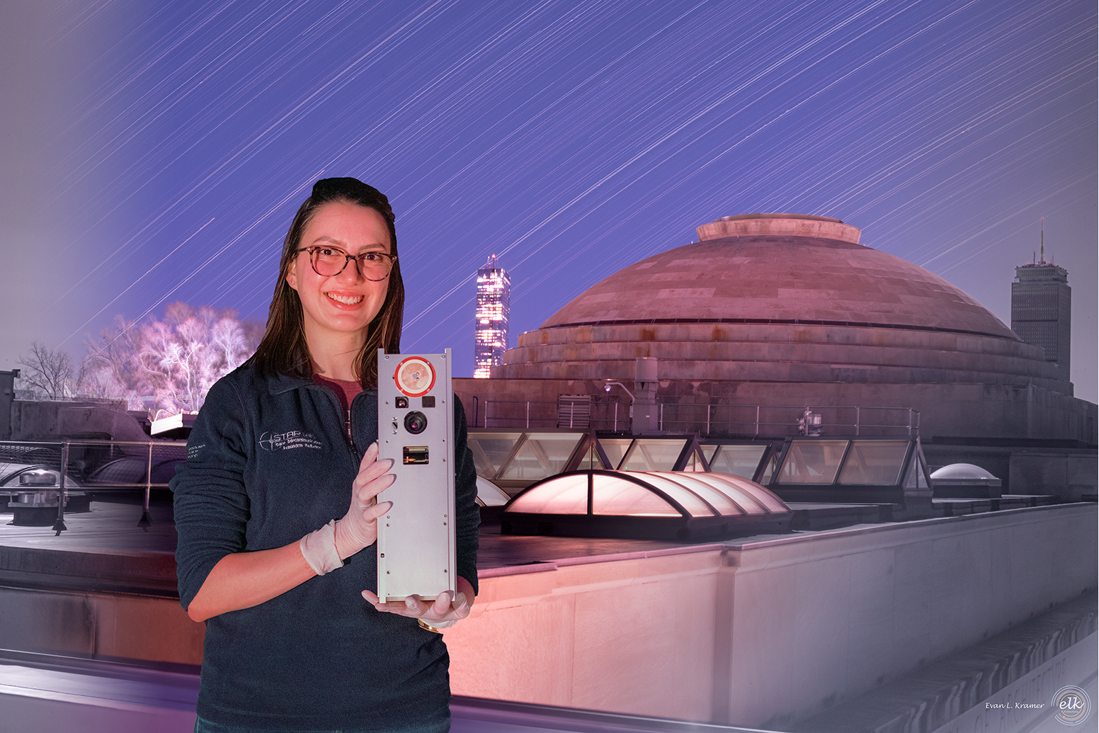 Paula do Vale Pereira with BeaverCube on MIT Building 9. Star trails and MIT mini dome in the background. Composite image of over 1,000 frames, includes visible and infrared waves from 400nm to 830nm.
