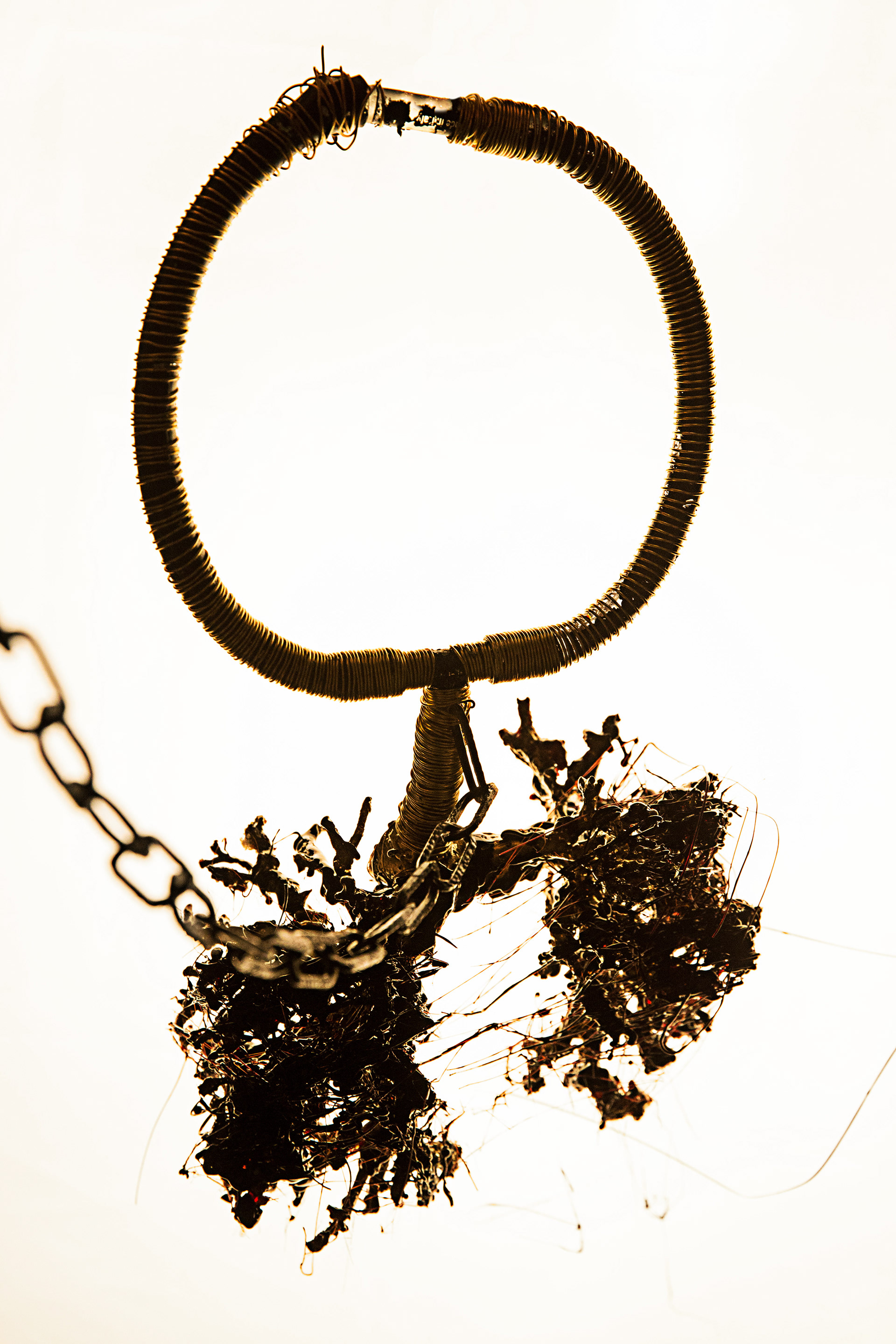 The golden wire obscures the tube system through which the smoke is pumped into the amuelet. The connection is hidden at the neck part.