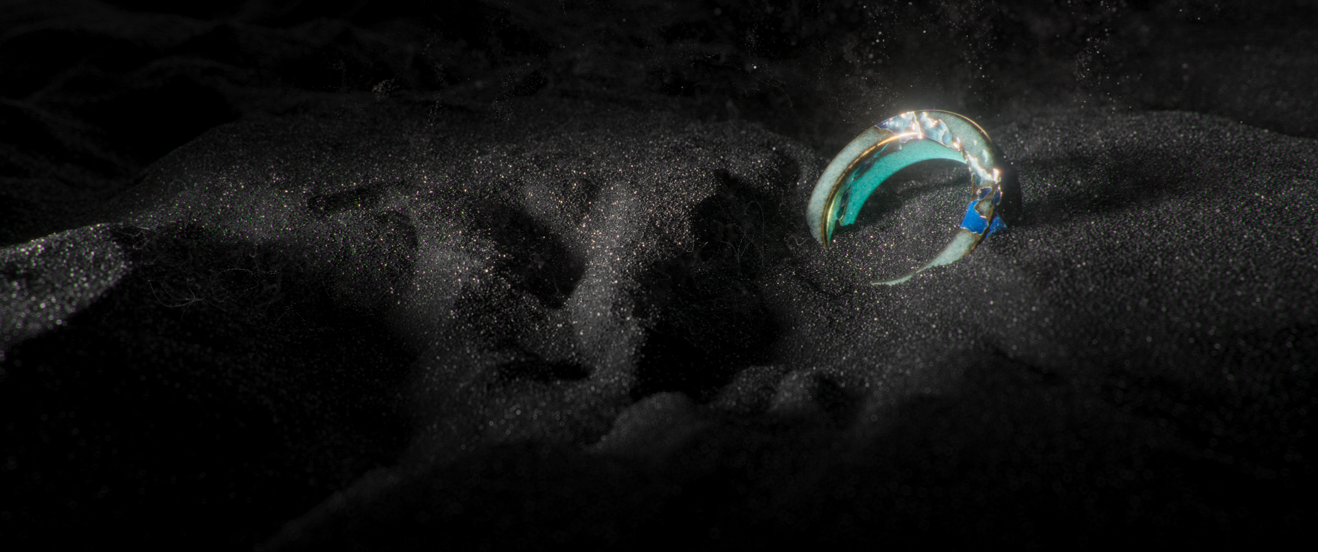 A 3D render of a beautiful ring on black sand by Tiago Higgs