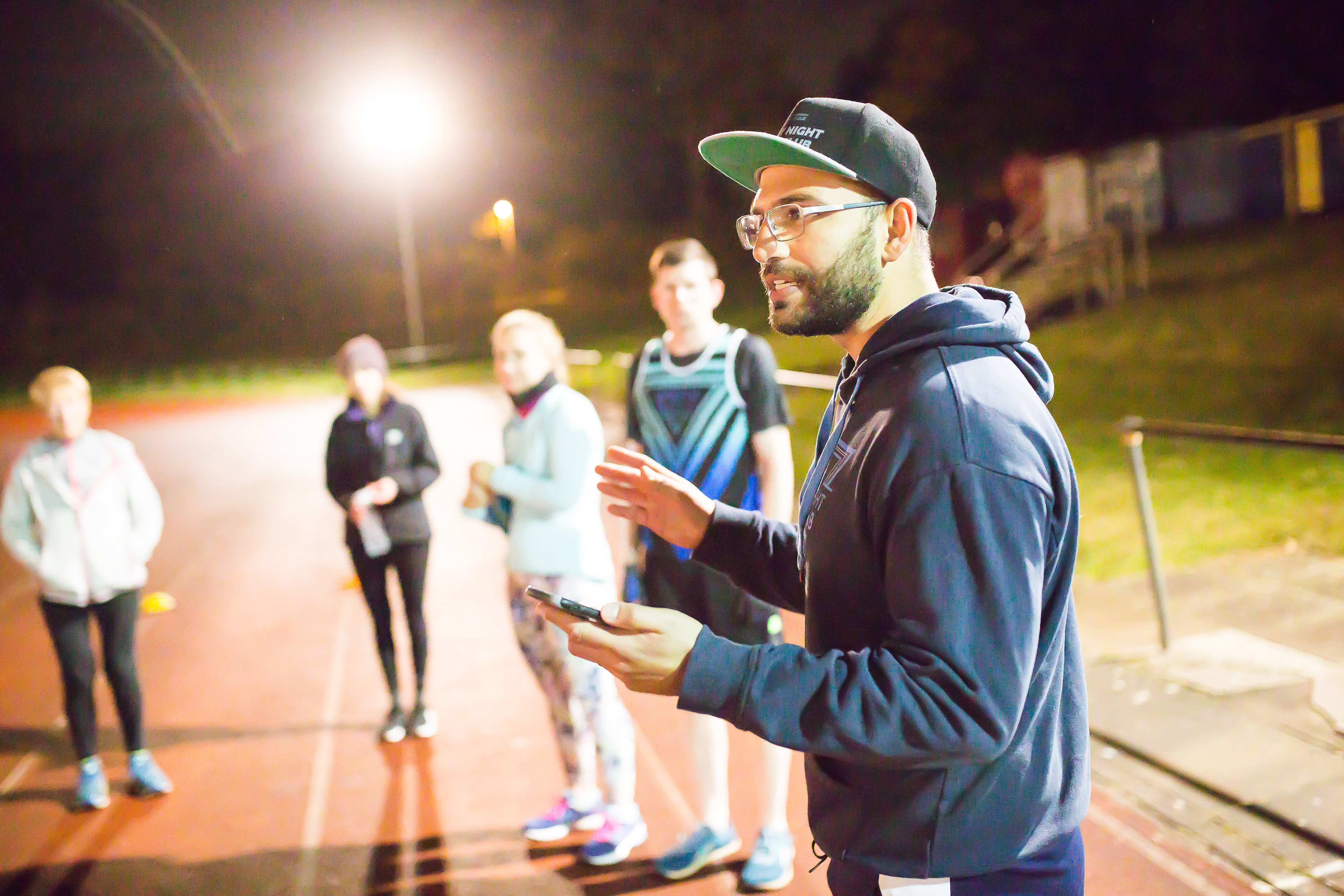 Running coach speaking to runners at Friday Night Track Club