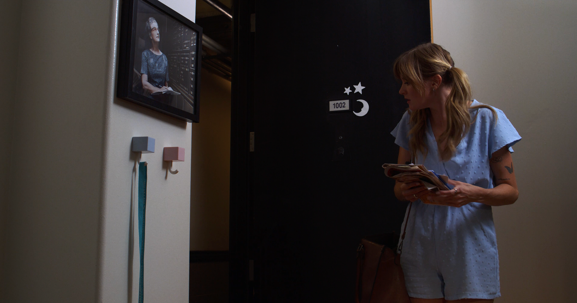 The moon and star symbol on her apartment door is the same symbol on Apollo's face in the final scene. The photo of Nancy Grace Roman is featured because she was the first female astrologer.