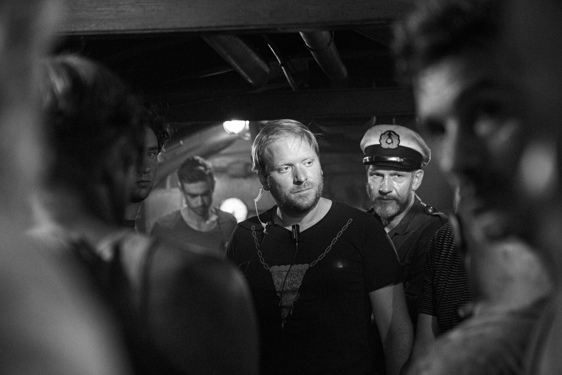 Assistant director, director of photography and focus puller meeting with actors for scene.