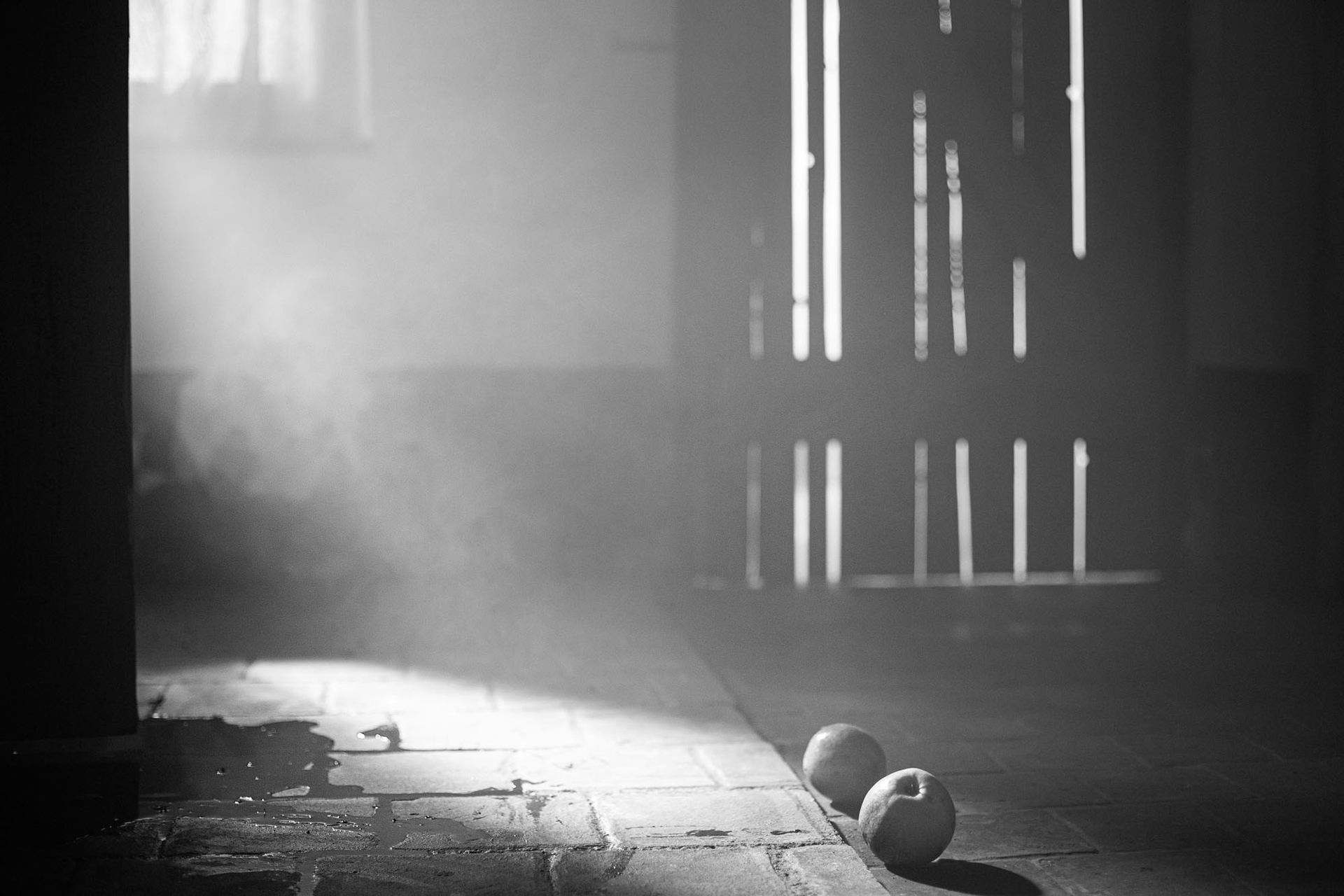 Still image of two apples on the ground with fake blood in the left corner.