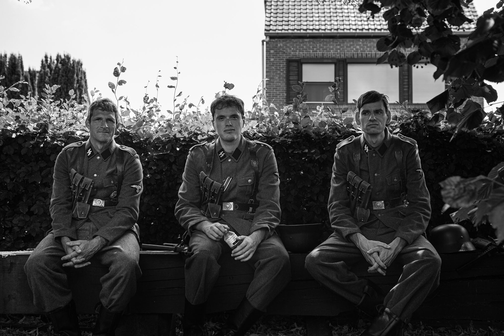 Three extras waiting on a bench outside, waiting to be called for scene.
