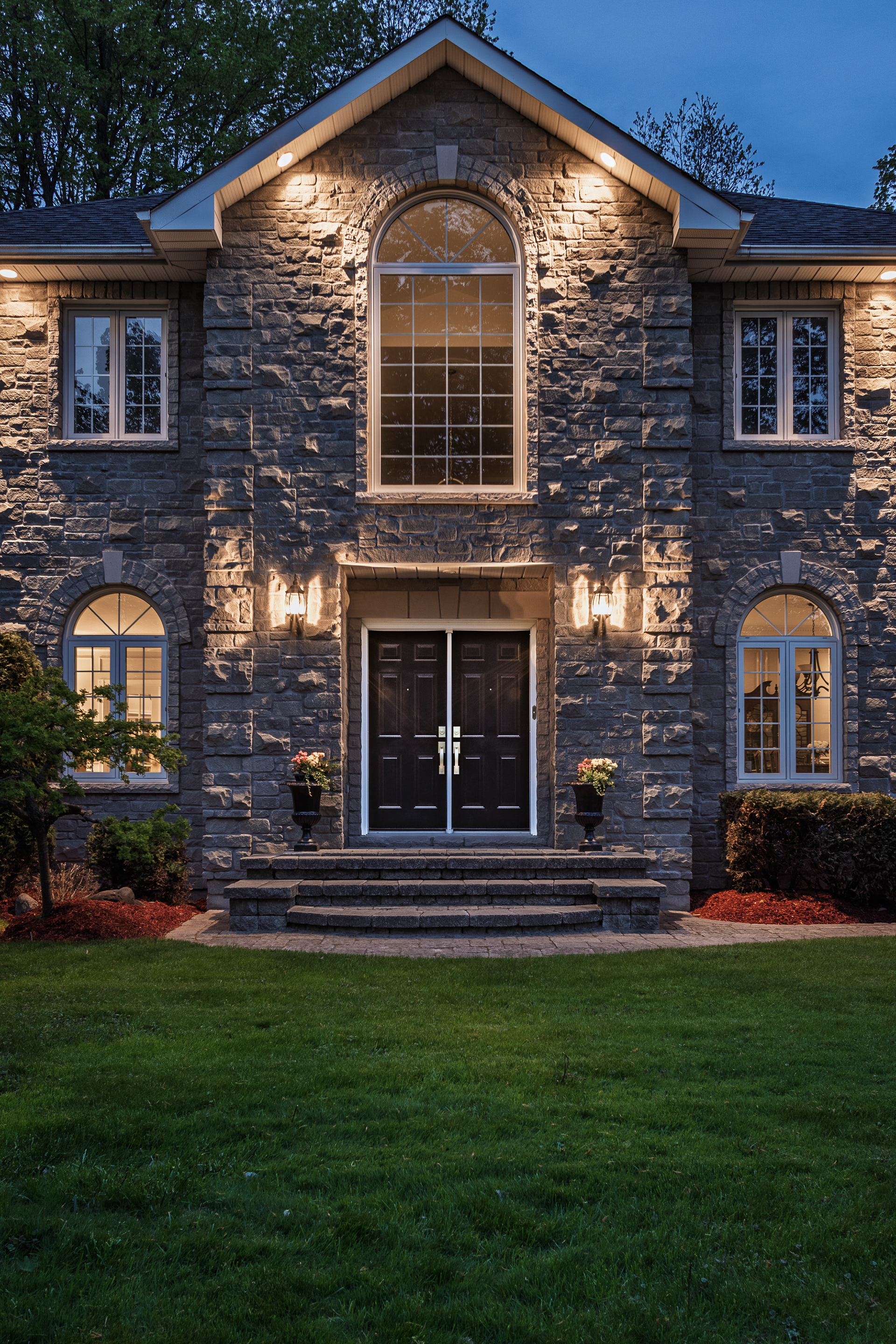 A closer perspective reveals the texture, symmetry, and warm architectural lighting of the home’s entrance.