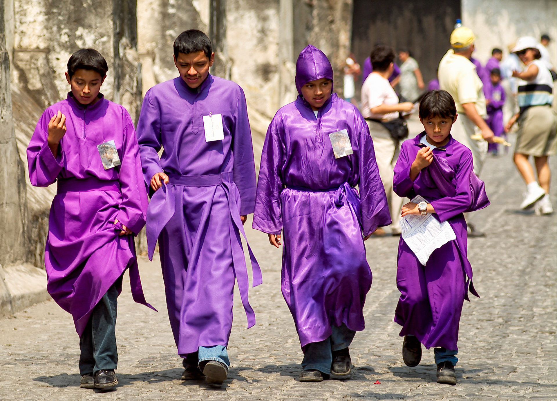 A group of young pallbearers dressed in purple robes walk on a street during Easter Thrusday procession in Antigua Guatemala, 20 miles west Guatemala City, 8th April 2004.  Easter thursday traditional procession carrying Jesus of Nazareth is from San Francisco El Grande a Dominican monastery in the historical city of Antigua.(Photo/Carlos Lopez-Barillas)
