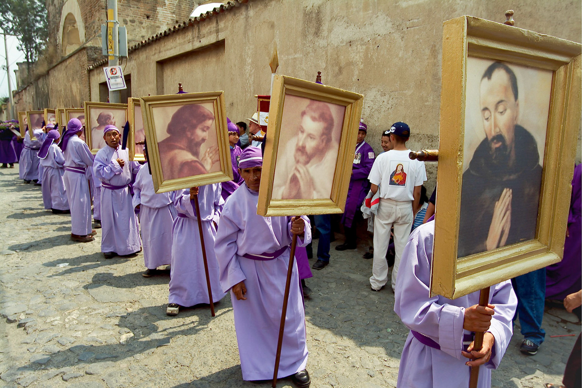 Men dressed in purple robes carry standards  with the pictures of the  Apostols while accompanying Easter Thrusday procession in Antigua Guatemala, 20 miles west Guatemala City, 8th April 2004.  Easter thursday traditional procession carrying Jesus of Nazareth is from San Francisco El Grande a Dominican monastery in the historical city of Antigua.(Photo/Carlos Lopez-Barillas)
