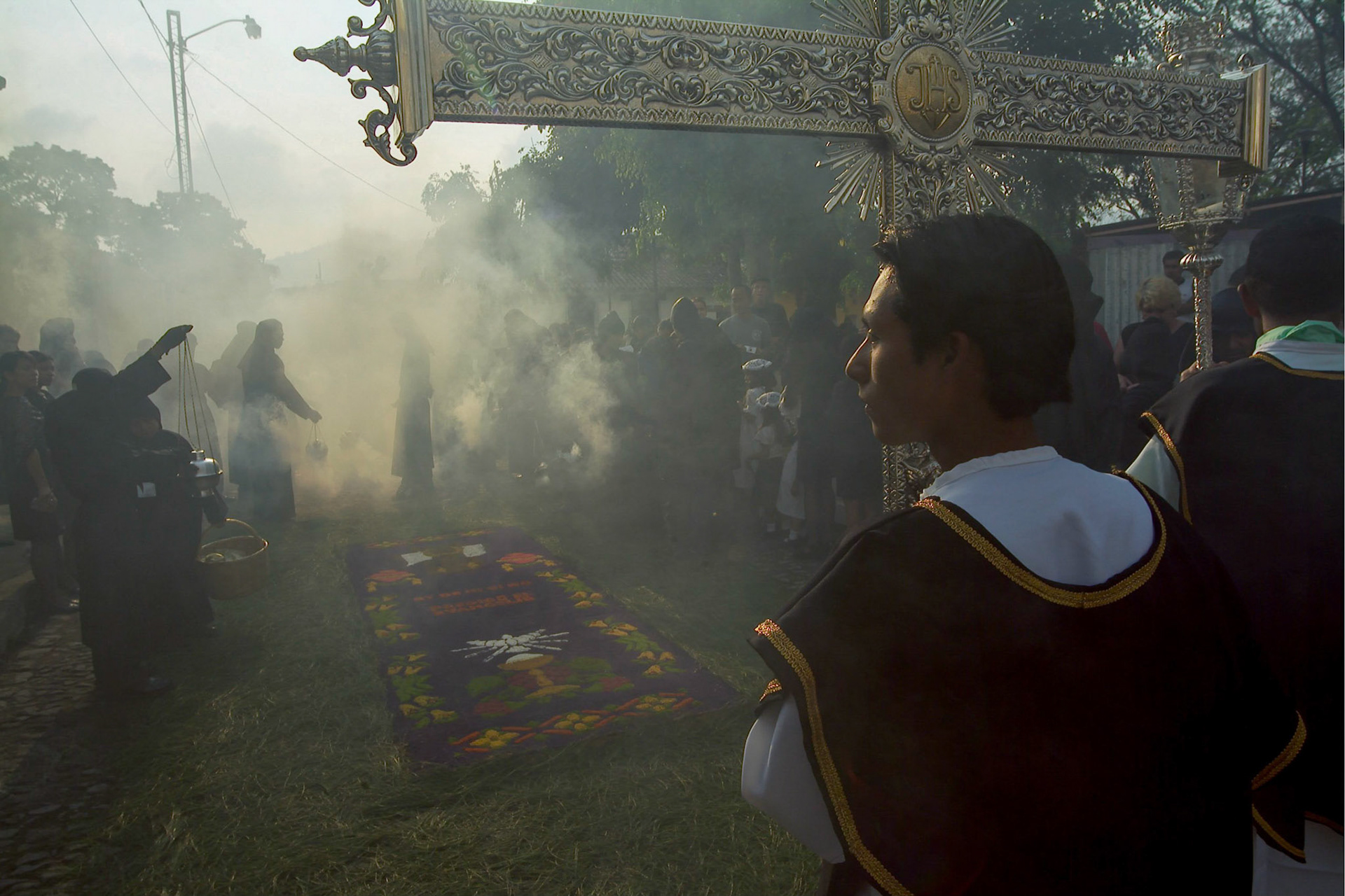A member from Escuela de Cristo brotherhood carries a cross during Easter Saturday procession in Antigua Guatemala, 20 miles west Guatemala City, 10th April 2004.(Photo/Carlos Lopez-Barillas)