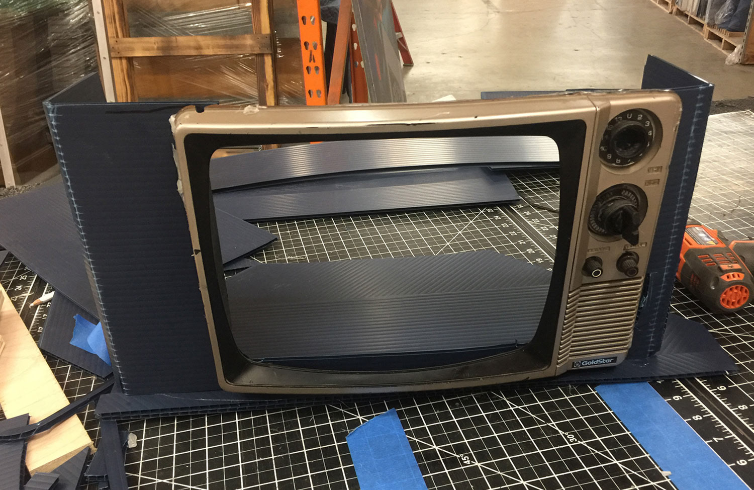 A Coroplast base secured the 19" flatscreen from the back and provided a backing for the trimmed magazine spines.