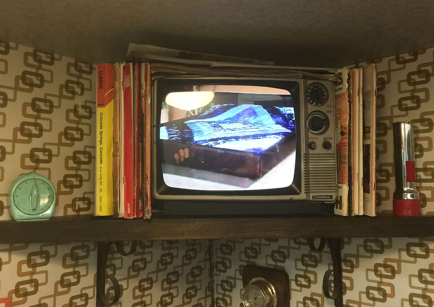 The Yellow Pages and magazines are just deep enough to hide the 19" flatscreen TV. I made a 4:3 aspect ratio mask in AfterEffects to camouflage the gap between the screen and the plastic facade.