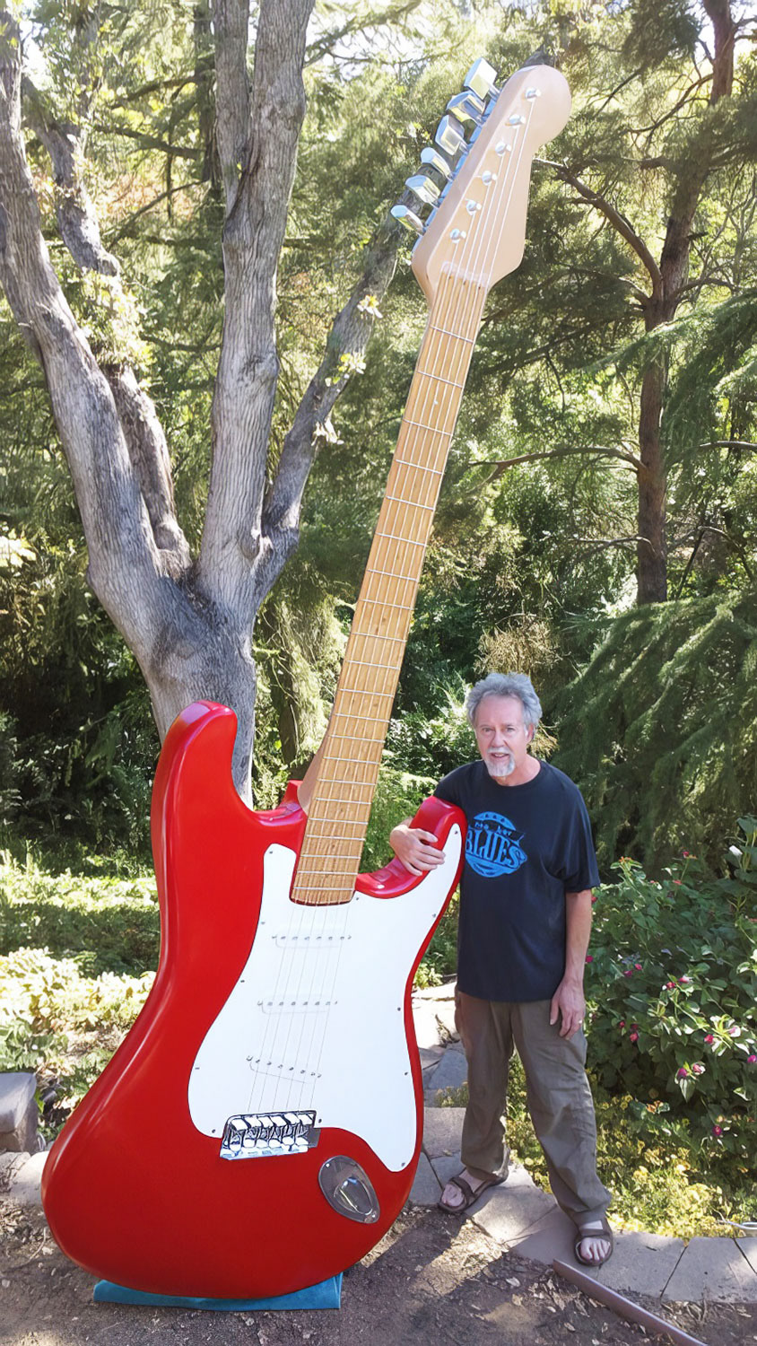 Not quite finished. No whammy bar or volume knobs at this point.   •    It only weighs 44 pounds, suspended by two eye bolts securely ‘glassed in to achieve the right viewing angle. The guitar is balanced at the eye bolts, and the neck is stabilized by a single wire to prevent it from swinging horizontally.