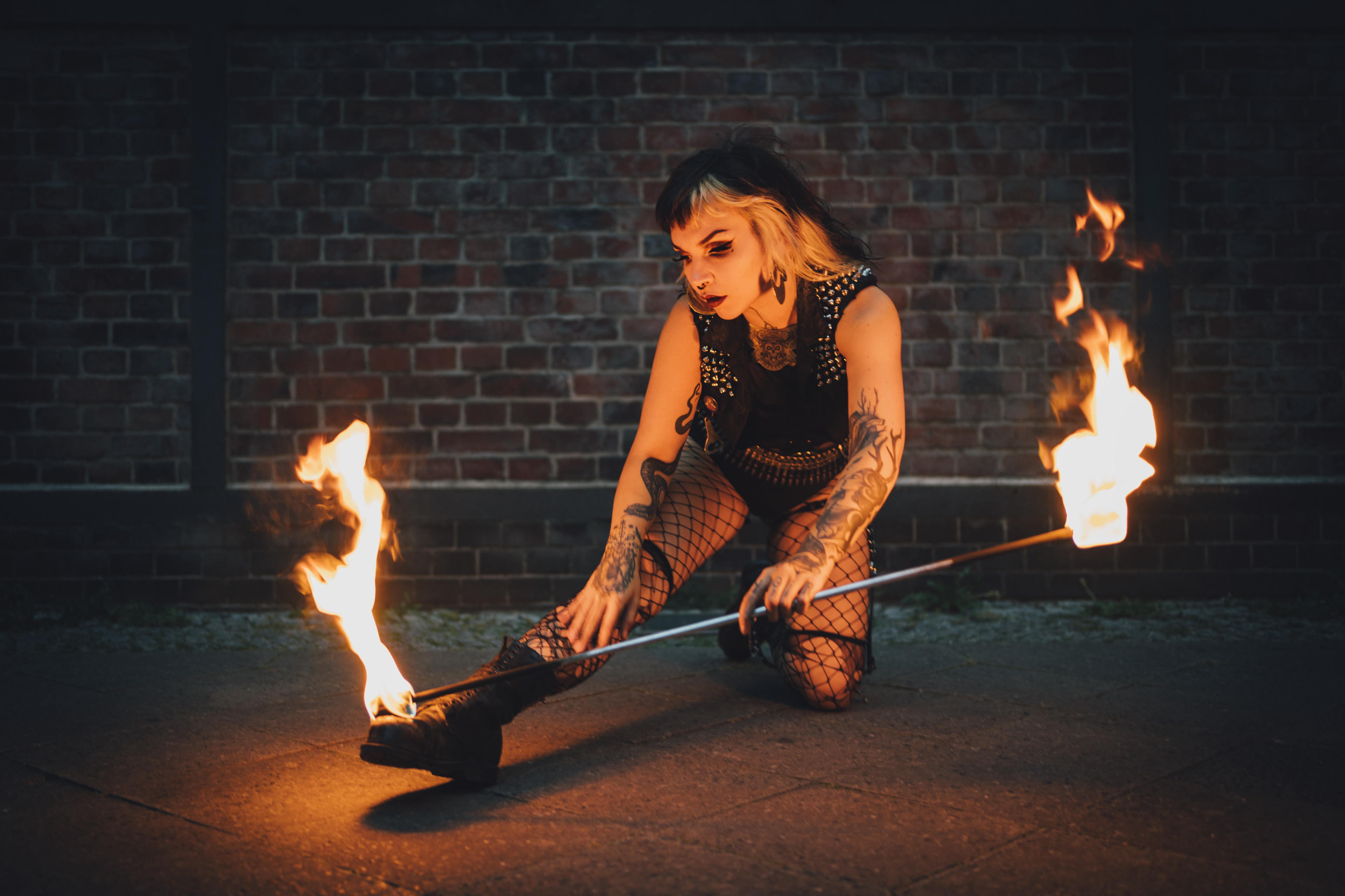 Performer of electric sideshow Evilyn Frantic captured during her fire show playing with the fire