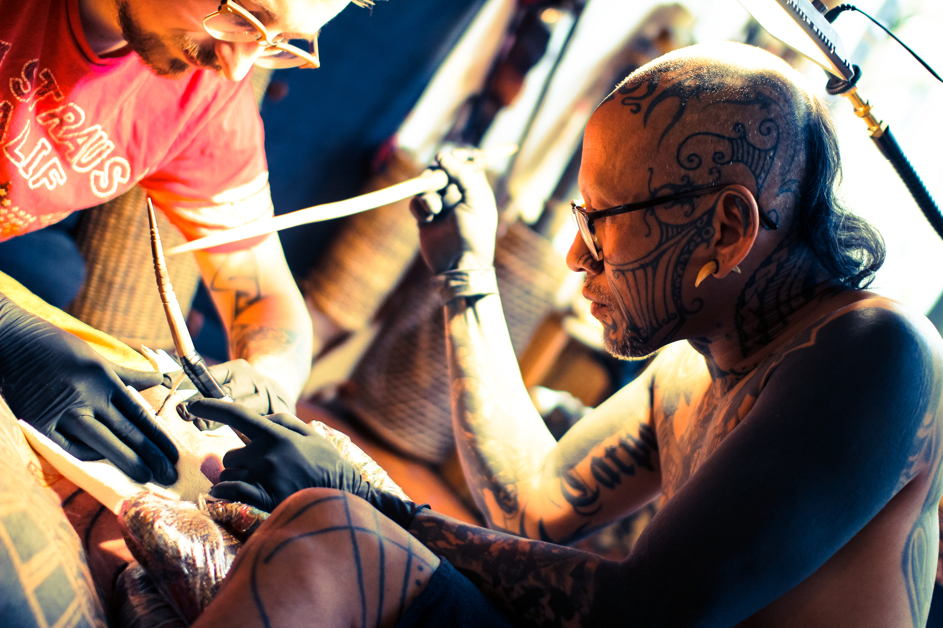 Tattoo artist Durga of Durga Tattoo working on Mentawai Ti'ti Mentawai tattoo using the traditional hand tapping instruments