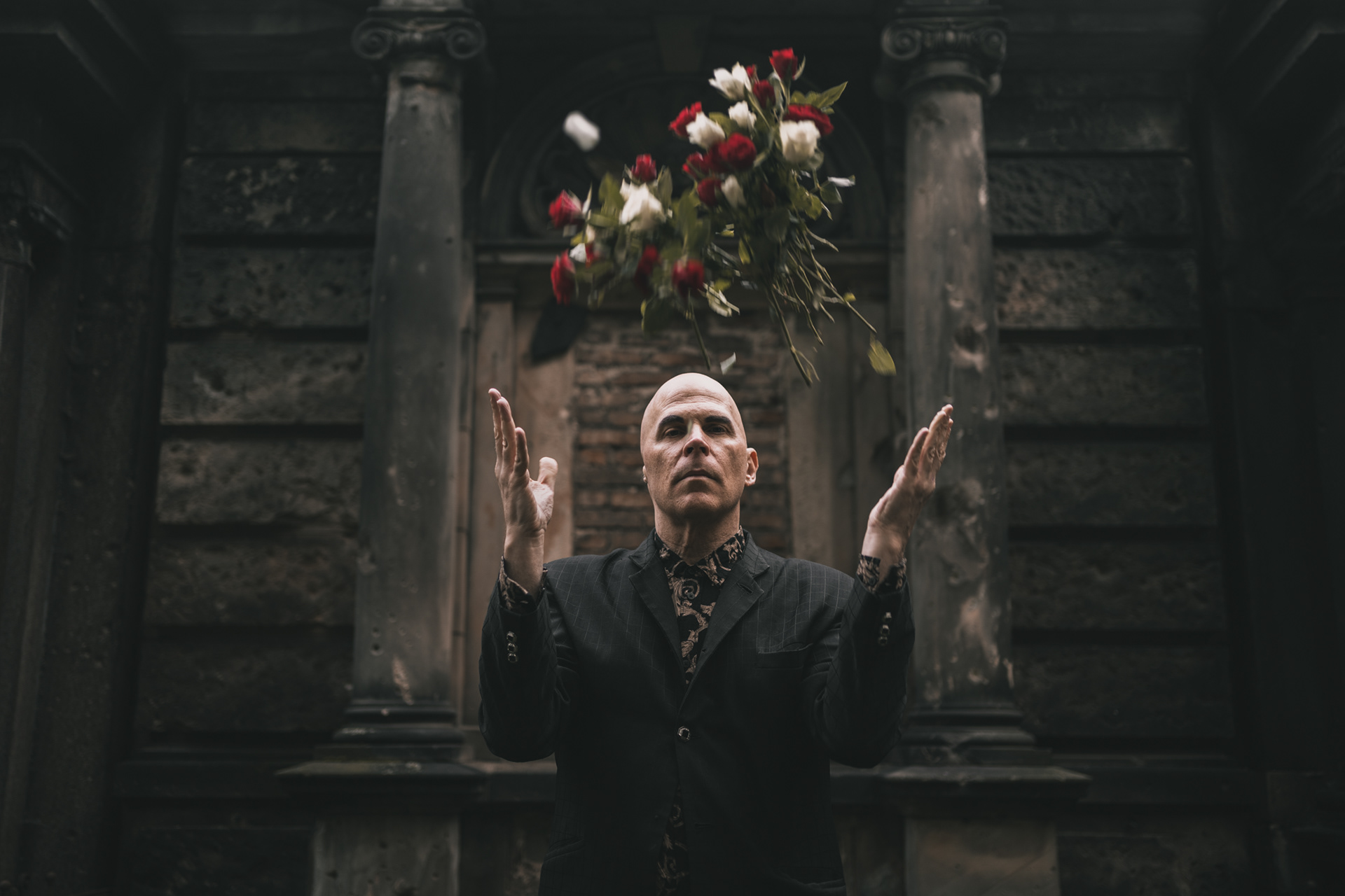 Nikolas Schreck american singer of death rock band Radio Werewolf throwing roses into the air at Georgen-Parochial Friedhof