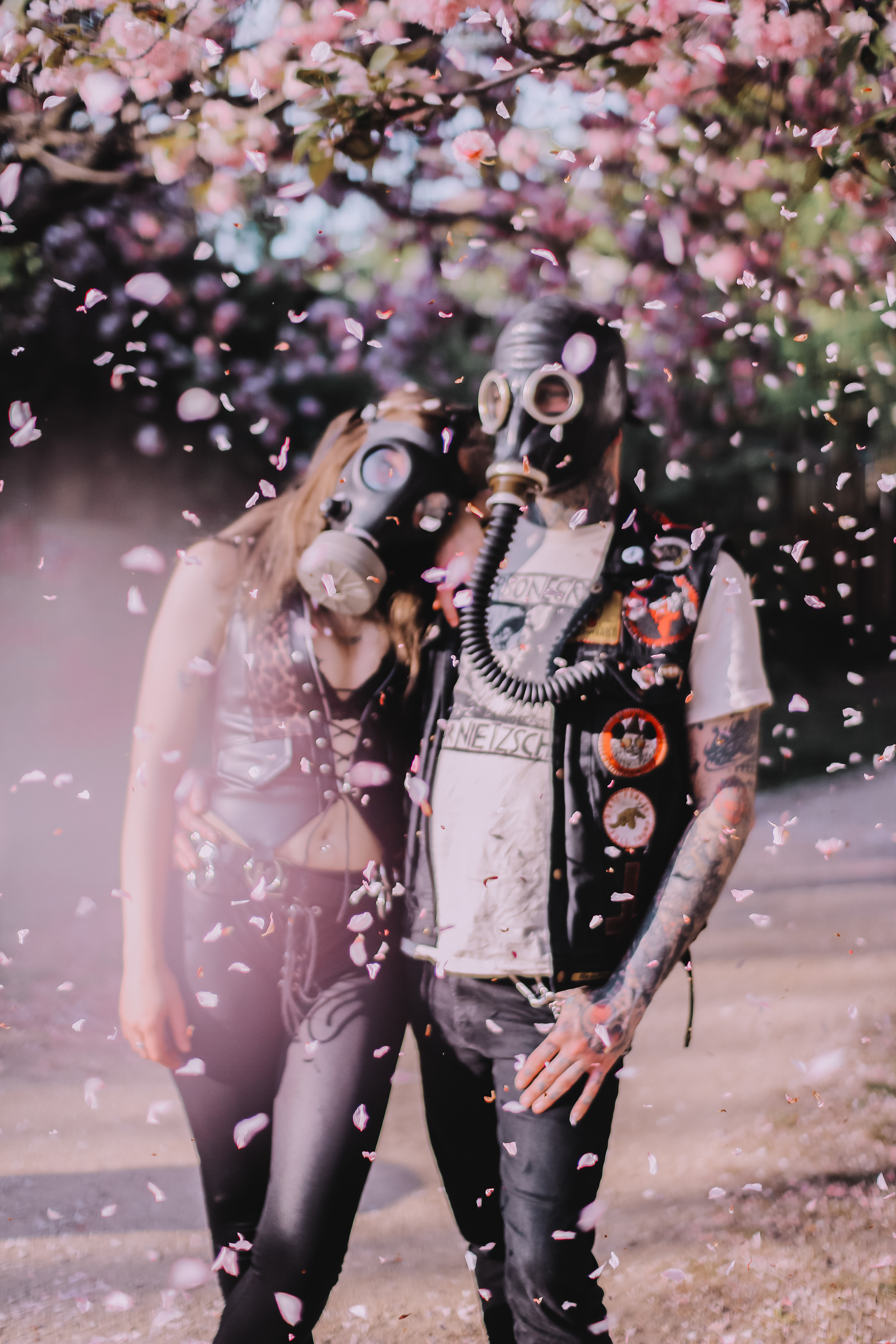 Pandemic Love Affair covid post apocalyptic series shot of a couple in love wearing gas masks under a cherry blossom tree