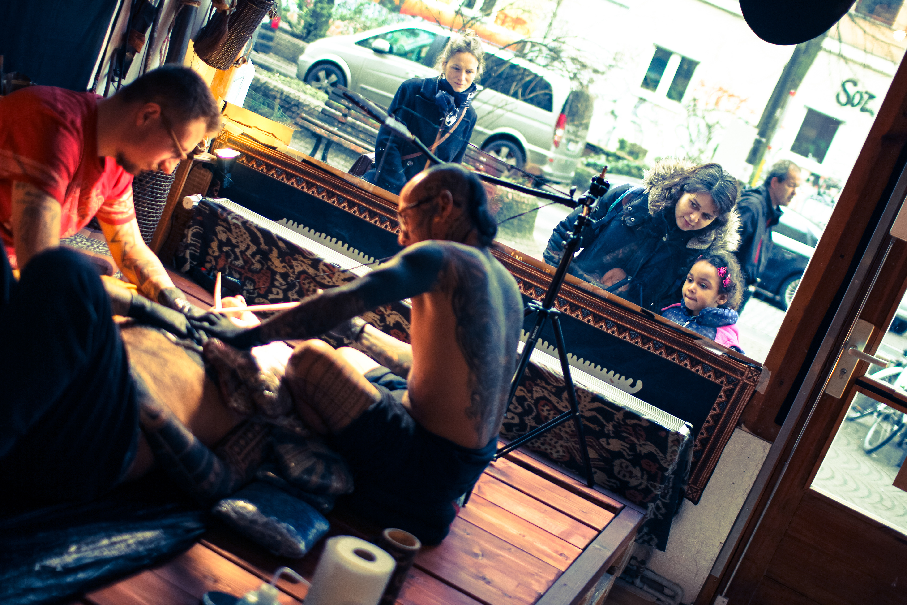 Customers looking through the window of Durga Tattoo shop in Berlin specialized in Mentawai Ti'ti Mentawai tattoo