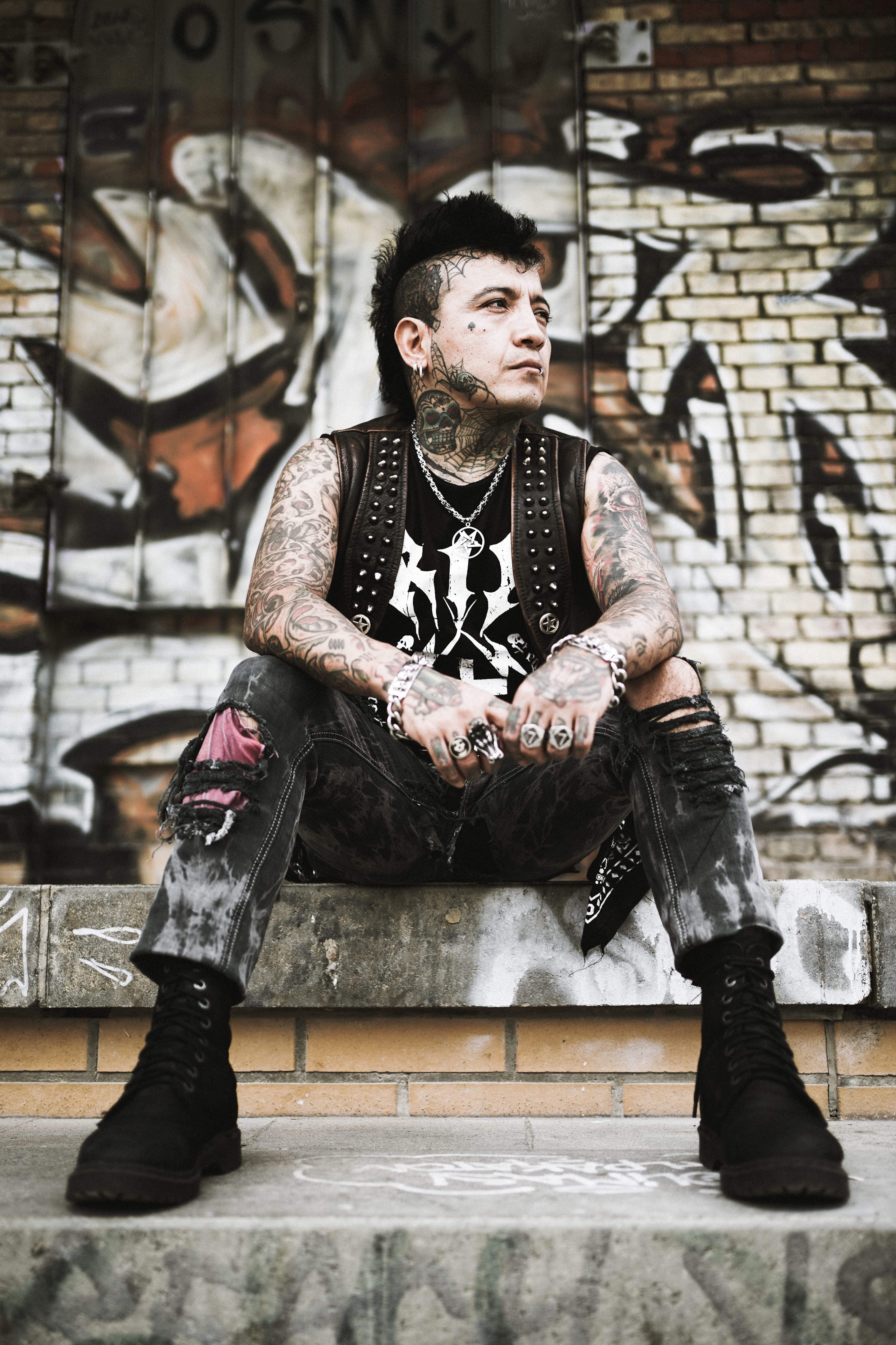 Chema Zurita the bass player of street punk band Booze & Glory sitting on the stairs in Berlin´s Görlitzer Park