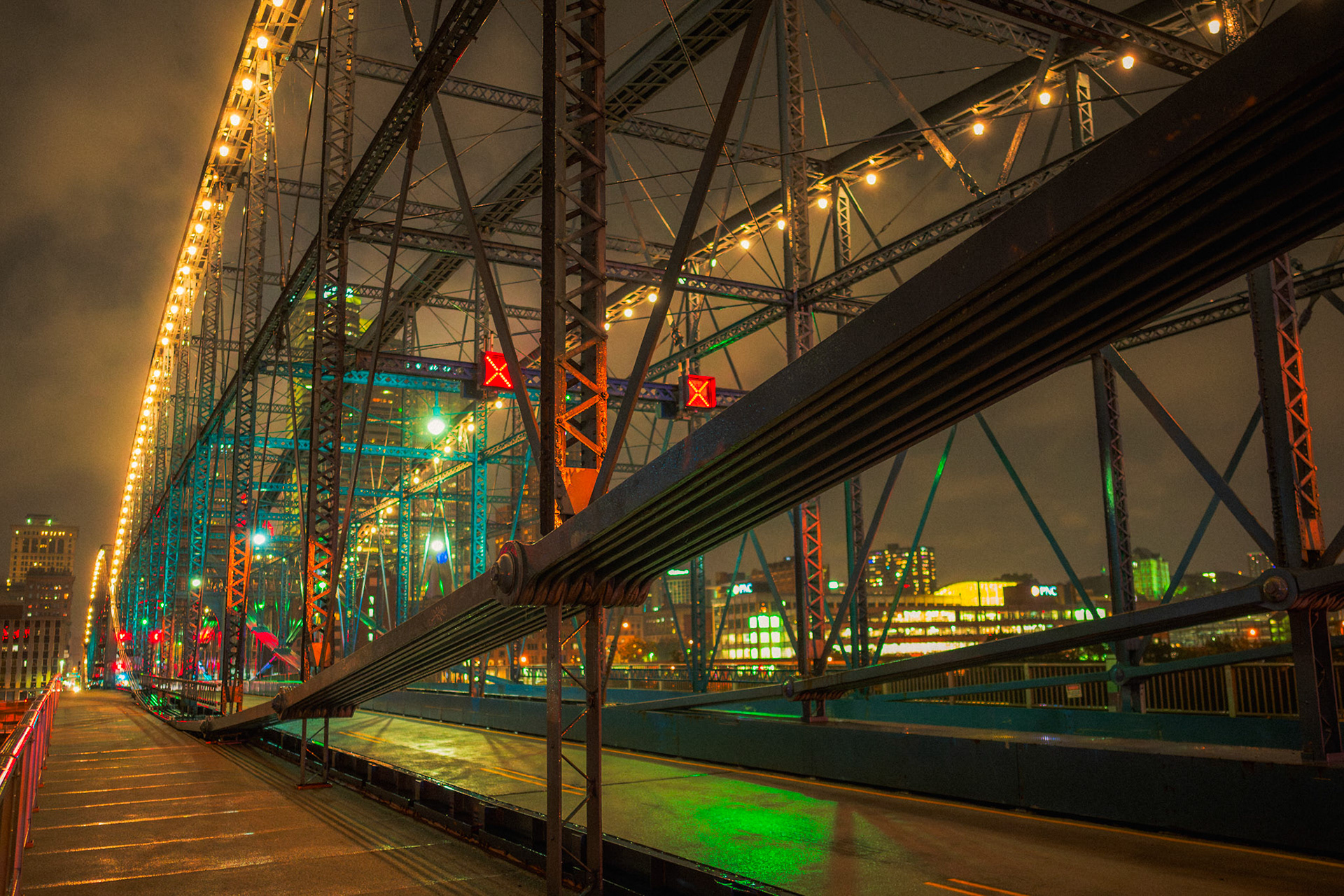 Veiled in mist, illuminated by steel. Pittsburgh's Smithfield Street Bridge transforms into a kaleidoscope of light and shadow on a rainy night.