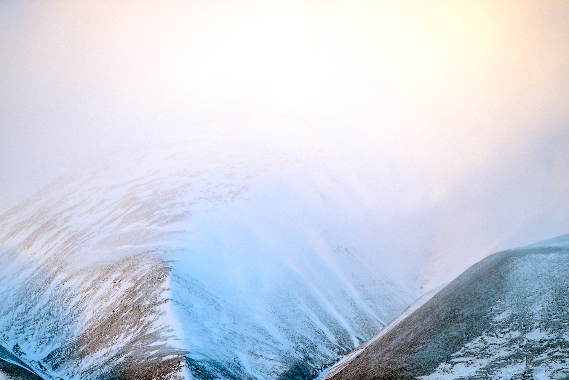 Where the land fades into light, and the cold air carries only silence. The mountains of Svalbard blur into the sky, their edges softened by drifting mist and the first glow of morning. A frozen world, untouched and infinite.
