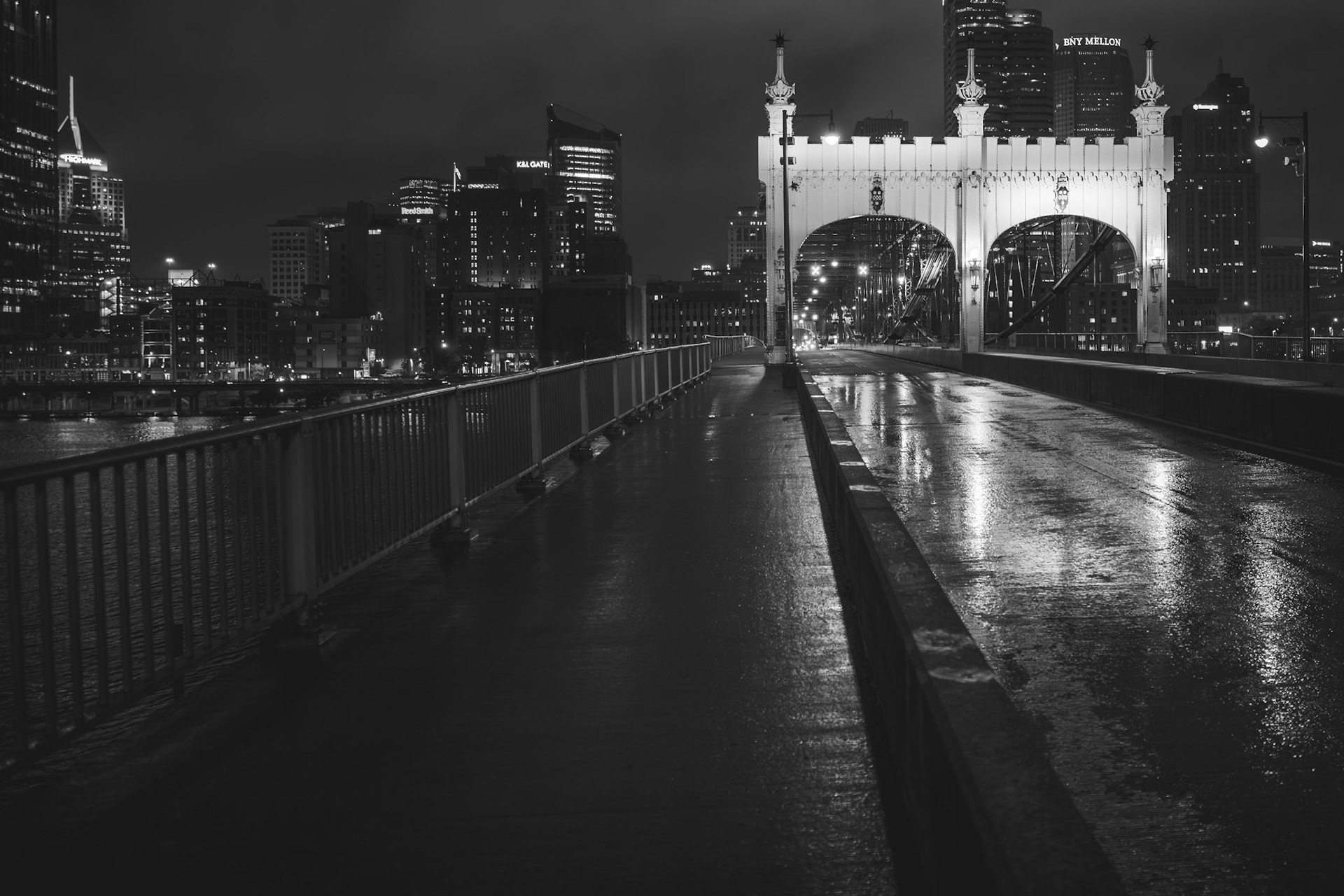 Pittsburgh's Smithfield Bridge shines through the mist, framing the vibrant skyline.