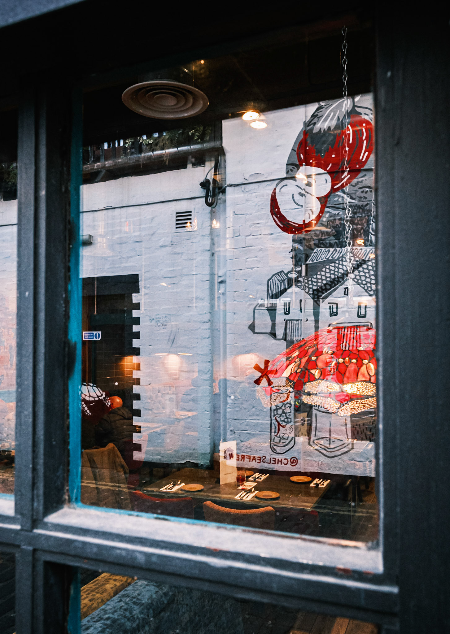 Reflections of the Art work on Ashton lane in the Ashoka's window.