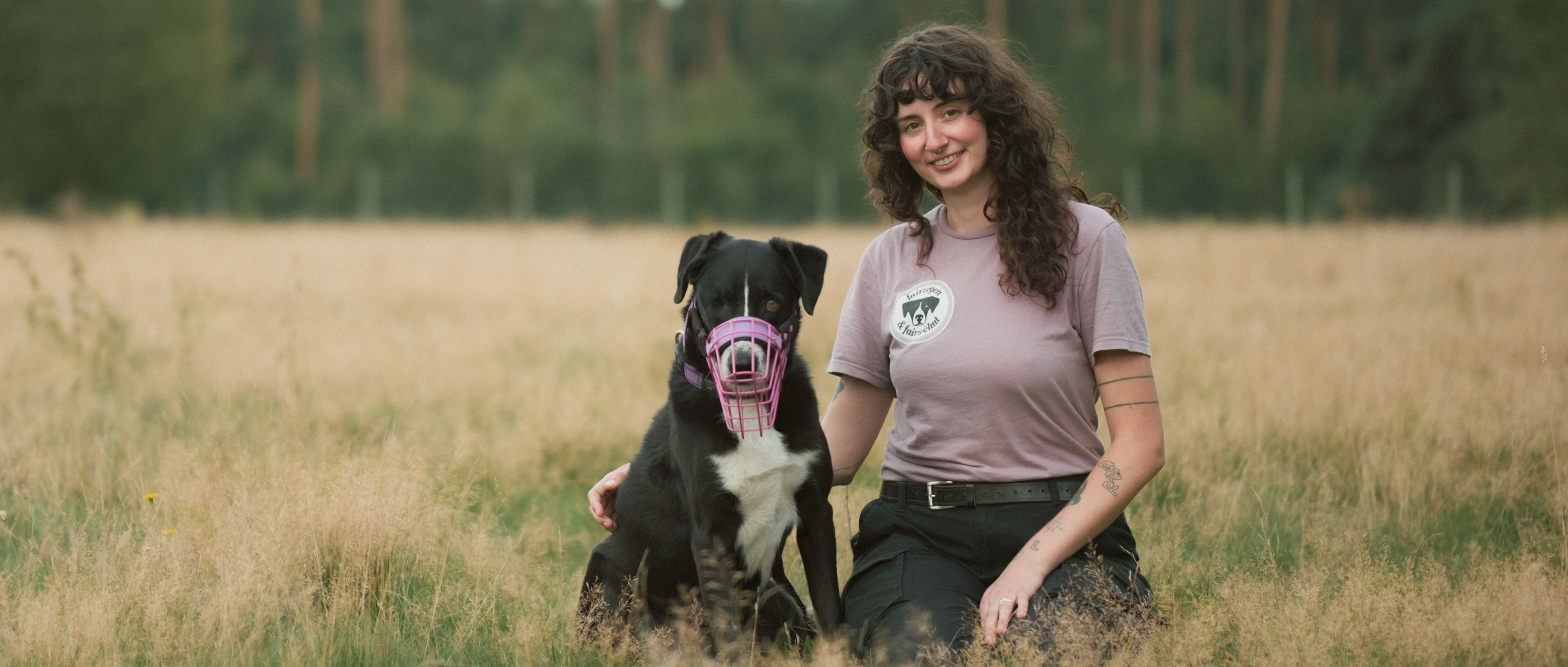 Levke, founder of fairzogen & fairwöhnt, is sitting next to her dog. She is smiling into the camera. It's a business photograph of her.
