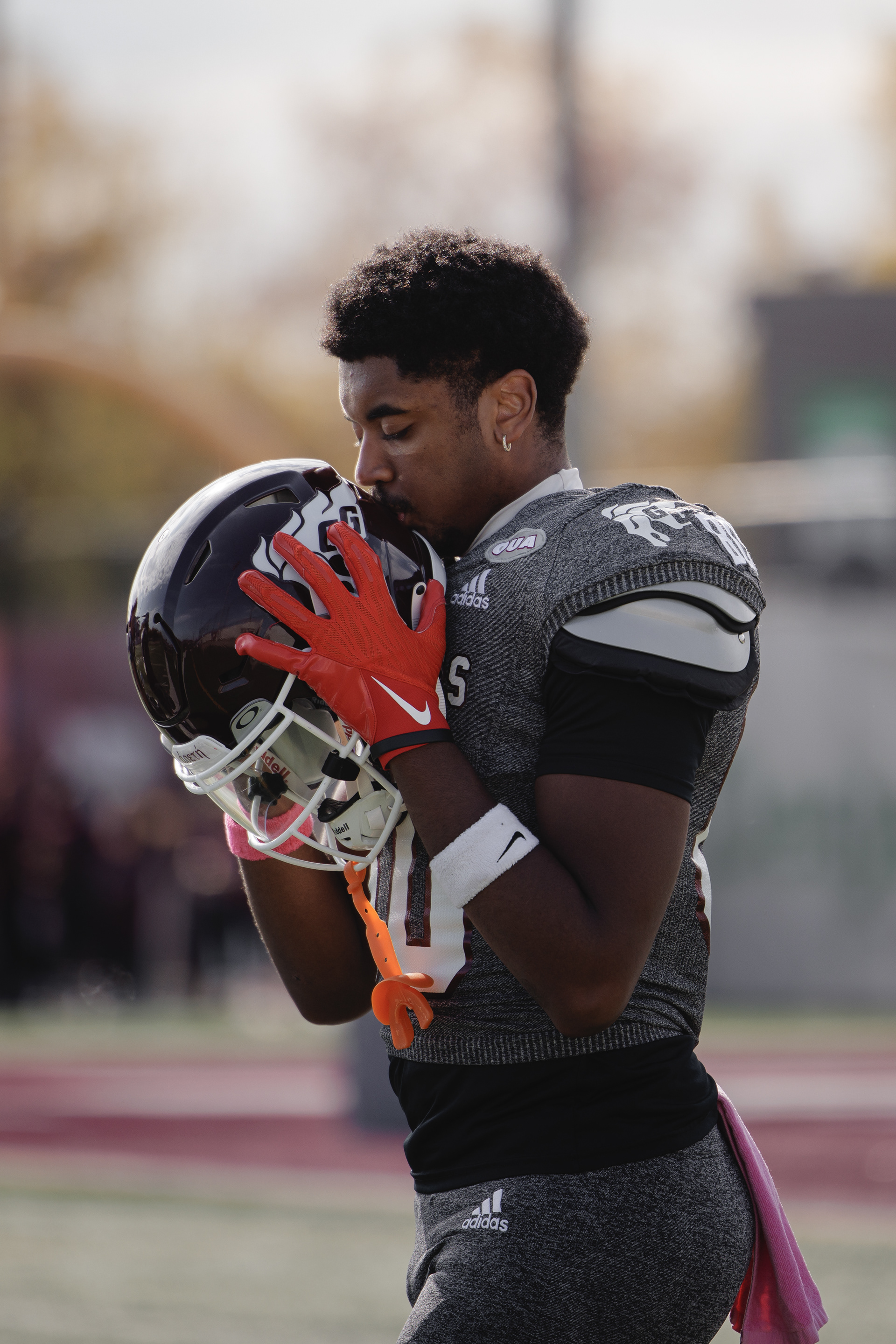 Wide Receiver Derrick Garraud-Boucard kisses his helmet following a pre-game prayer.