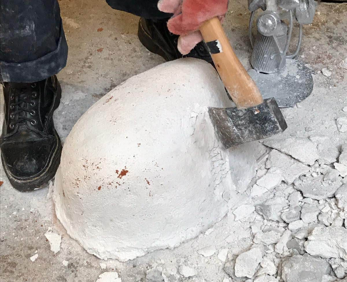 Breaking apart the plaster mold to reveal the casted aluminum tree.