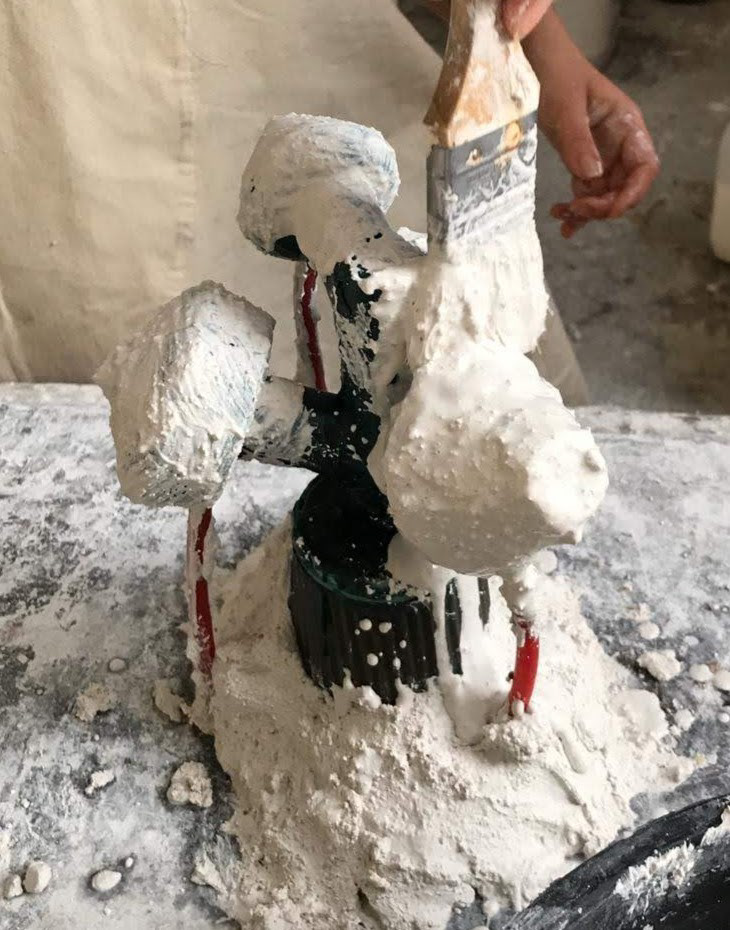 Assembling the plaster mold, building in layers with increased material coarseness and a final layer of chicken wire for structure.