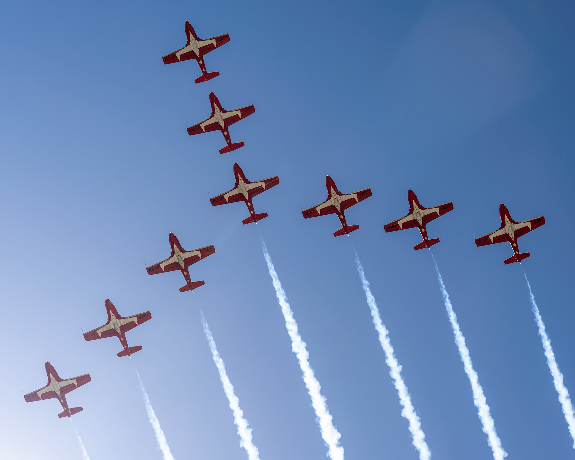 The Canadian Forces Snowbirds (431 Air Demonstration Squadron) perform a precision formation flight, leaving signature white smoke trails against a clear sky during their 2026 spring training demonstration over Vancouver Island. Fine art aviation photography by Kevin Prentice.