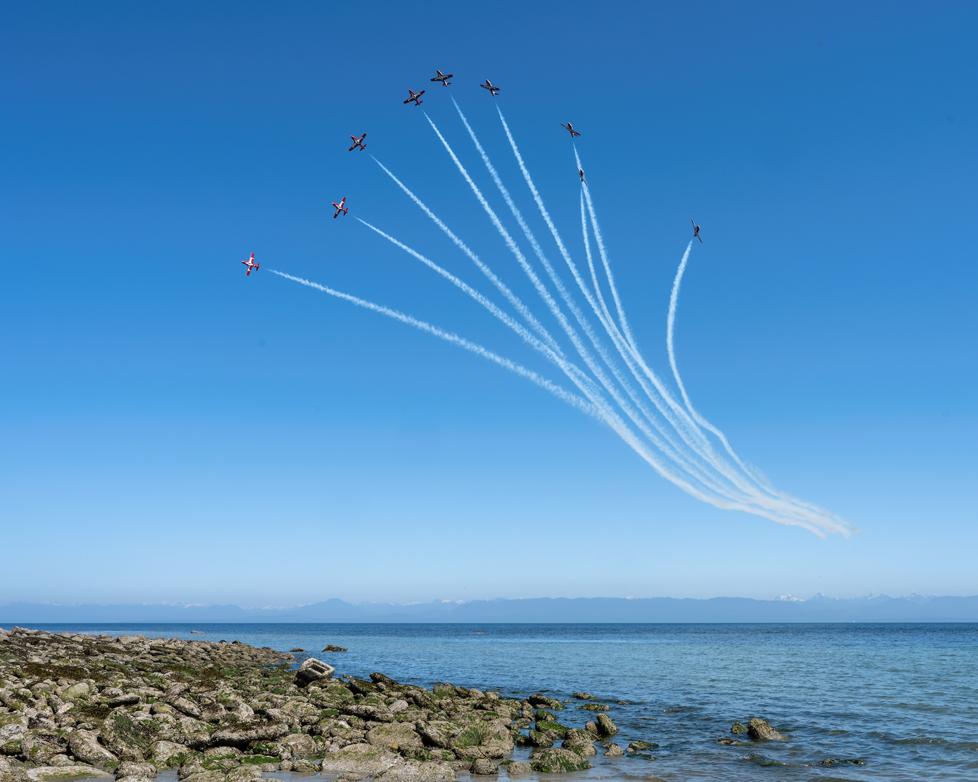 The Canadian Forces Snowbirds (431 Air Demonstration Squadron) perform a precision formation flight, leaving signature white smoke trails against a clear sky during their 2026 spring training demonstration over Vancouver Island. Fine art aviation photography by Kevin Prentice.