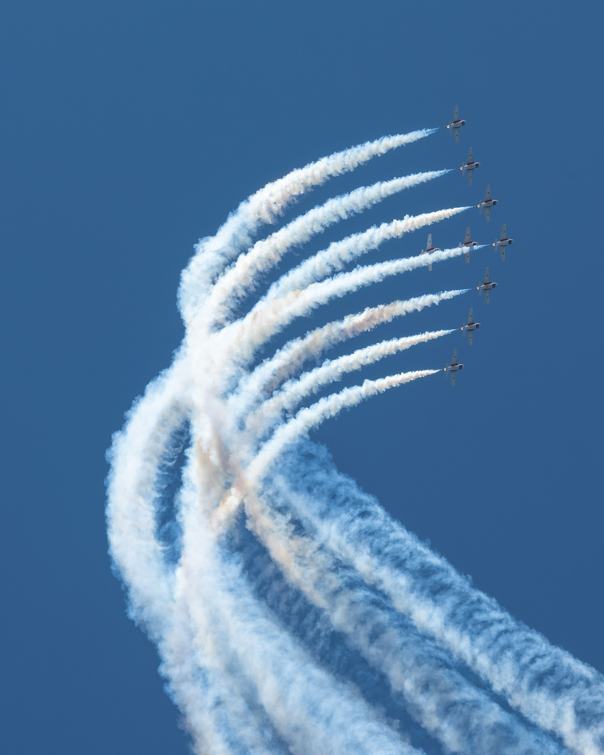 The Canadian Forces Snowbirds (431 Air Demonstration Squadron) perform a precision formation flight, leaving signature white smoke trails against a clear sky during their 2026 spring training demonstration over Vancouver Island. Fine art aviation photography by Kevin Prentice.