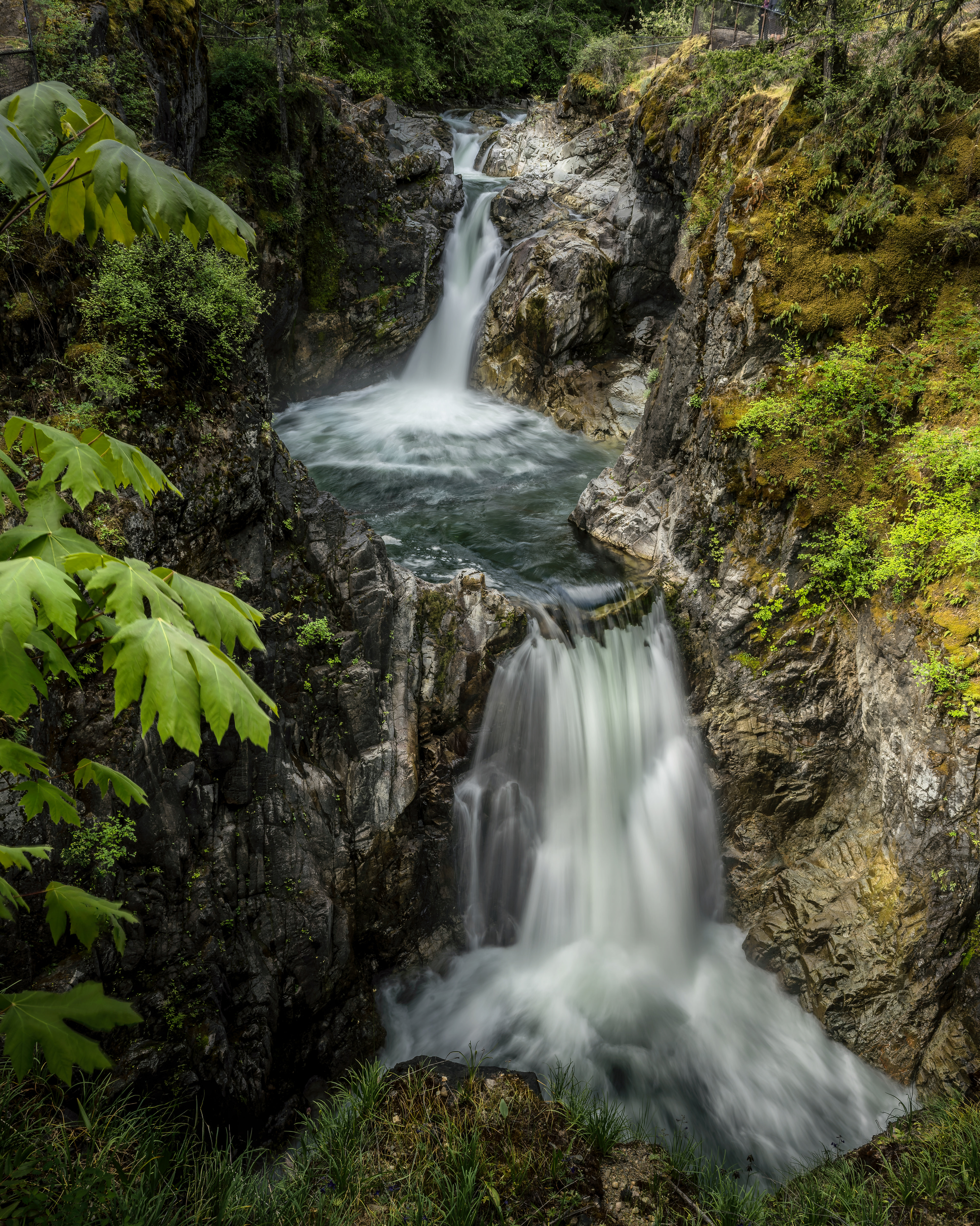 A beautiful long-exposure view of the multi-tiered cascades rushing through the rocky gorge at Little Qualicum Falls Provincial Park on Vancouver Island, British Columbia. Fine art landscape photography by Kevin Prentice.