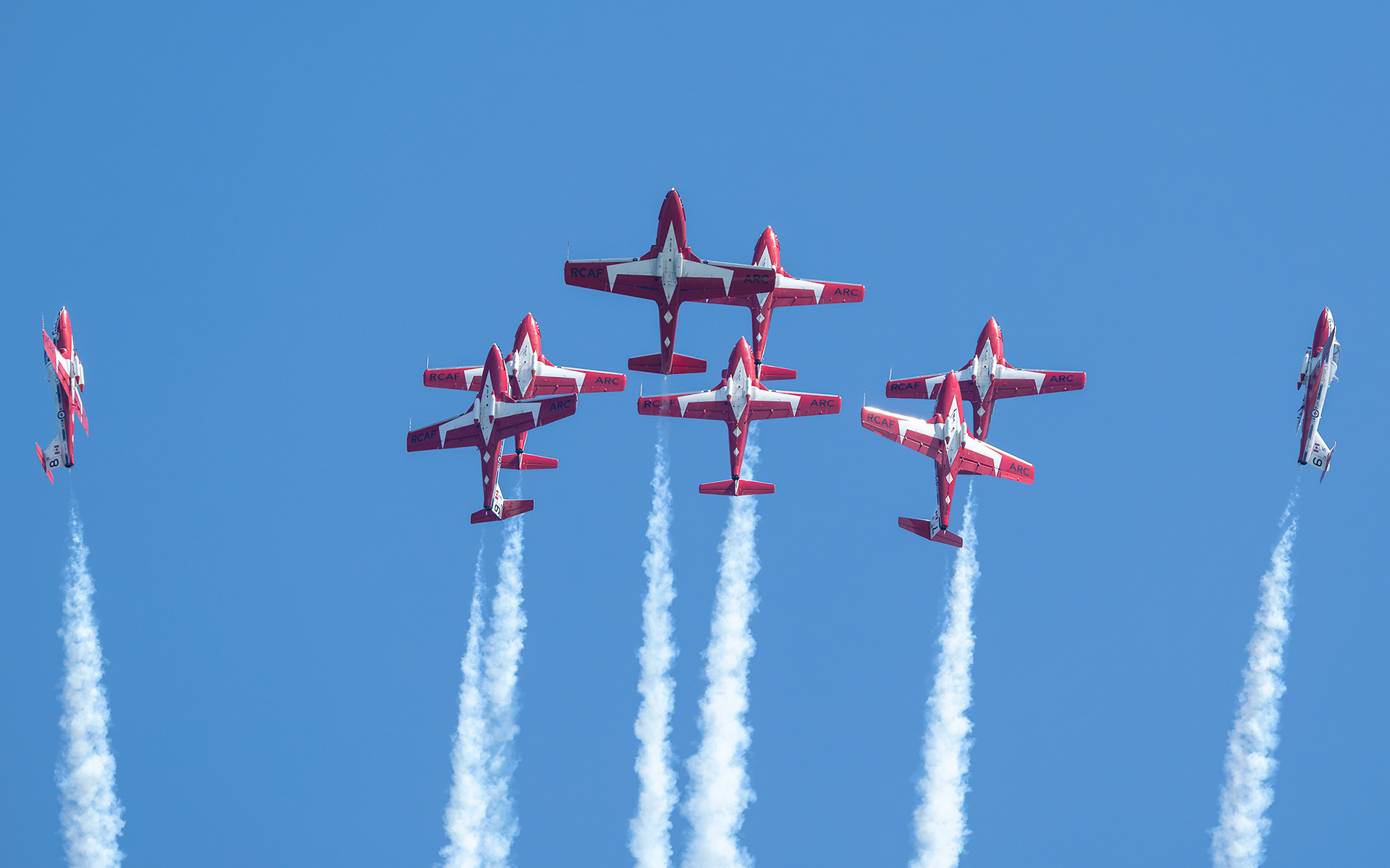 The Canadian Forces Snowbirds (431 Air Demonstration Squadron) perform a precision formation flight, leaving signature white smoke trails against a clear sky during their 2026 spring training demonstration over Vancouver Island. Fine art aviation photography by Kevin Prentice.