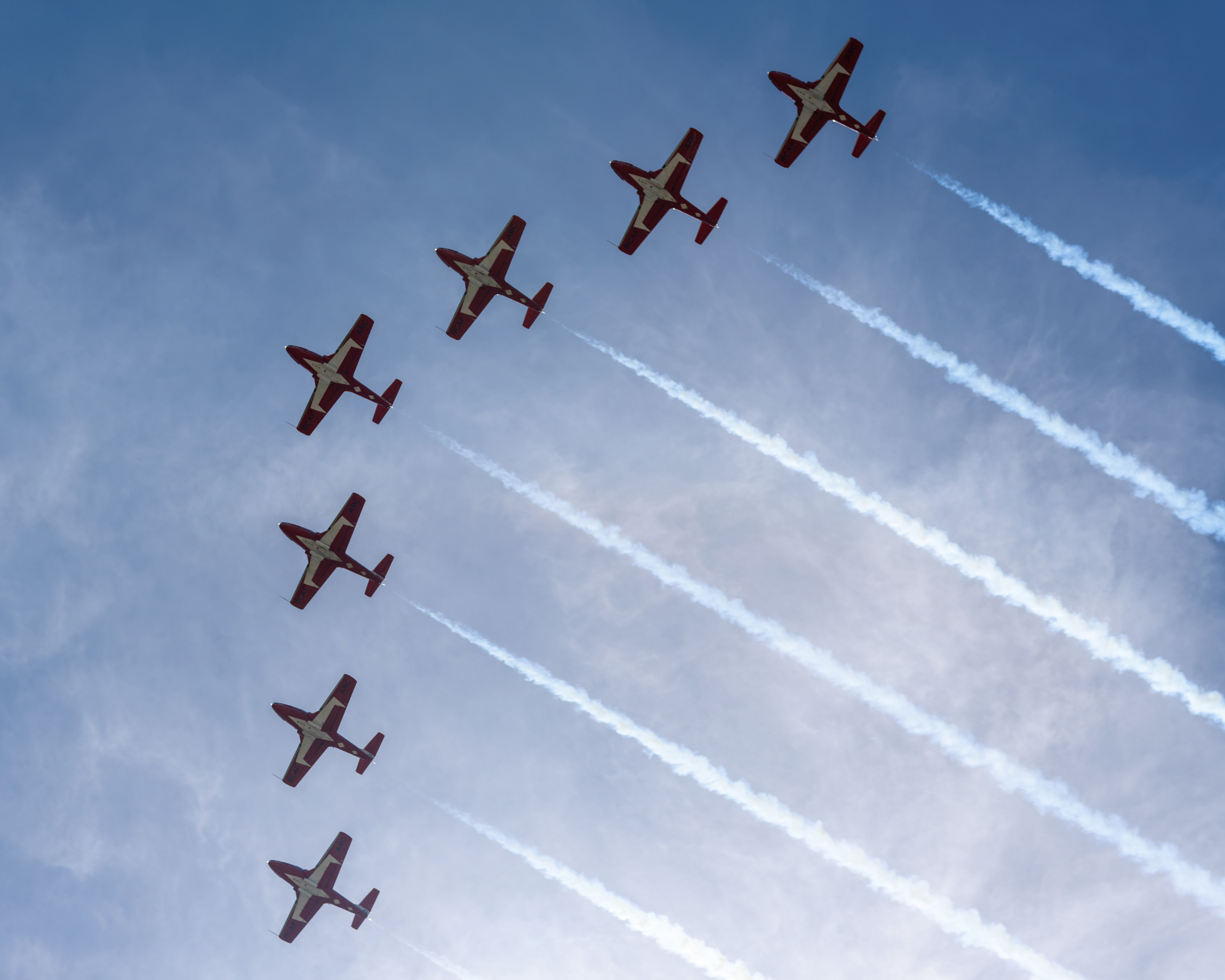 The Canadian Forces Snowbirds (431 Air Demonstration Squadron) perform a precision formation flight, leaving signature white smoke trails against a clear sky during their 2026 spring training demonstration over Vancouver Island. Fine art aviation photography by Kevin Prentice.