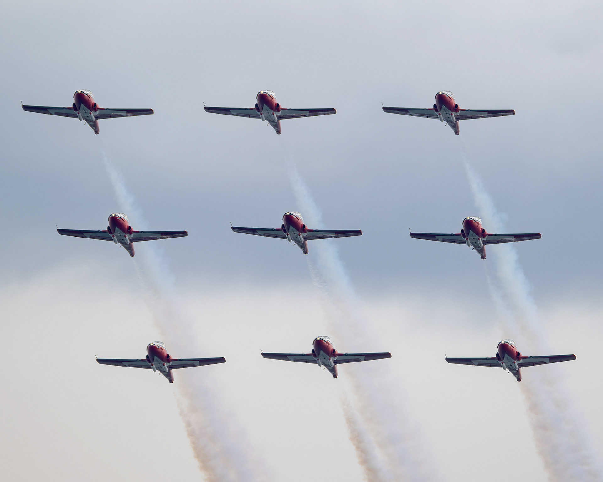 The Canadian Forces Snowbirds (431 Air Demonstration Squadron) perform a precision formation flight, leaving signature white smoke trails against a clear sky during their 2026 spring training demonstration over Vancouver Island. Fine art aviation photography by Kevin Prentice.
