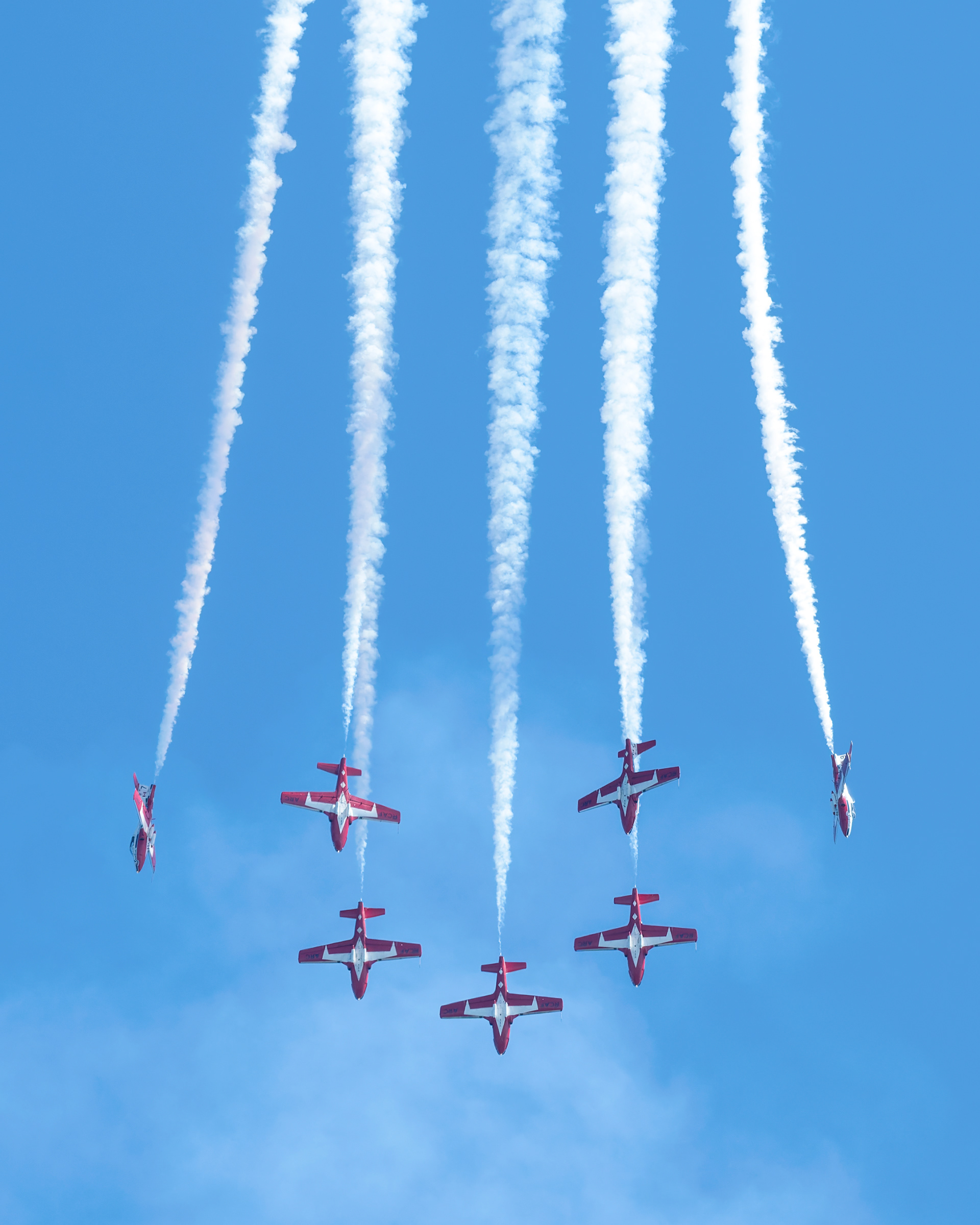 The Canadian Forces Snowbirds (431 Air Demonstration Squadron) perform a precision formation flight, leaving signature white smoke trails against a clear sky during their 2026 spring training demonstration over Vancouver Island. Fine art aviation photography by Kevin Prentice.