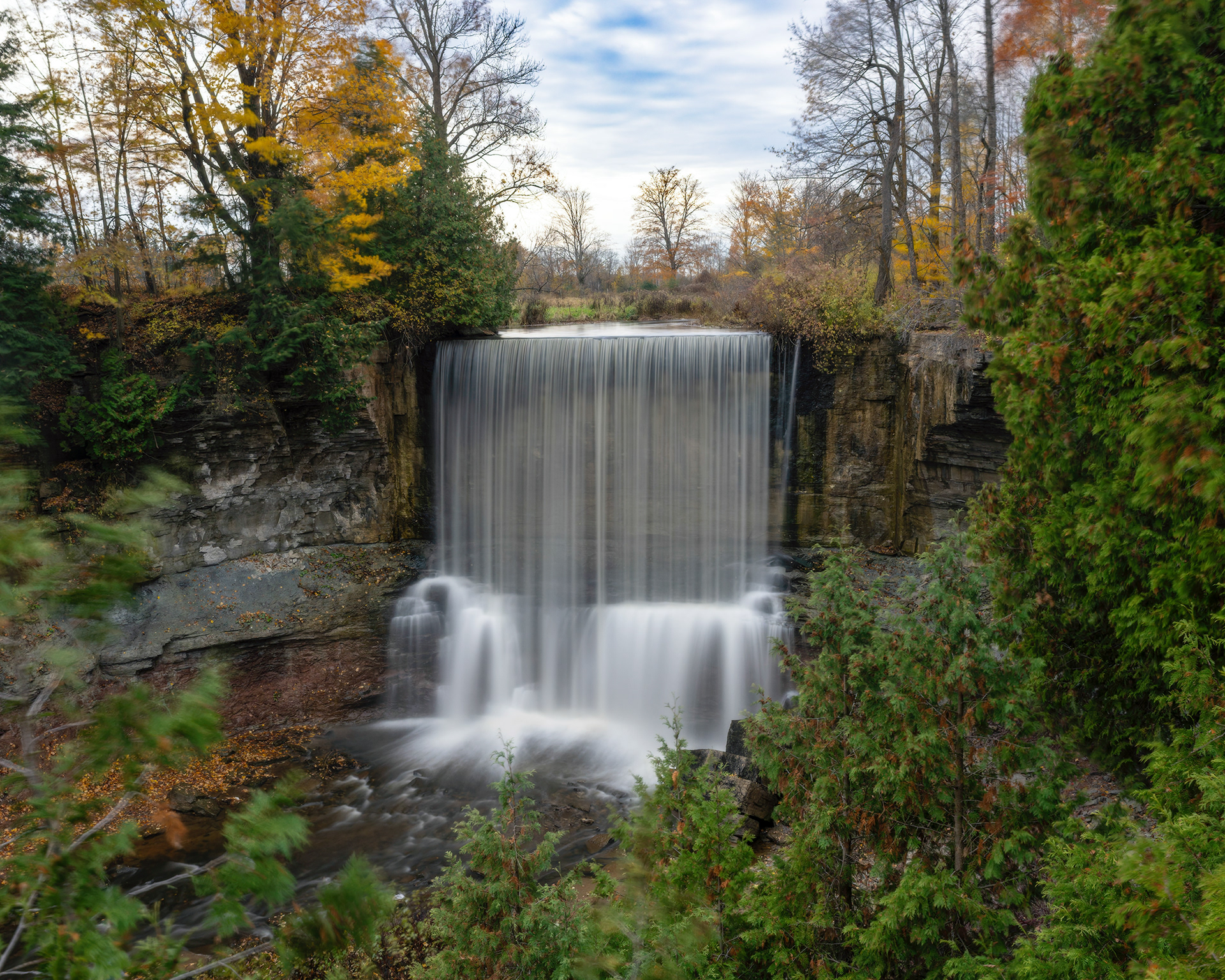 A stunning autumn view of the 15-meter horseshoe-shaped Indian Falls cascading over the Niagara Escarpment near Owen Sound, Ontario. Fine art landscape photography by Kevin Prentice.