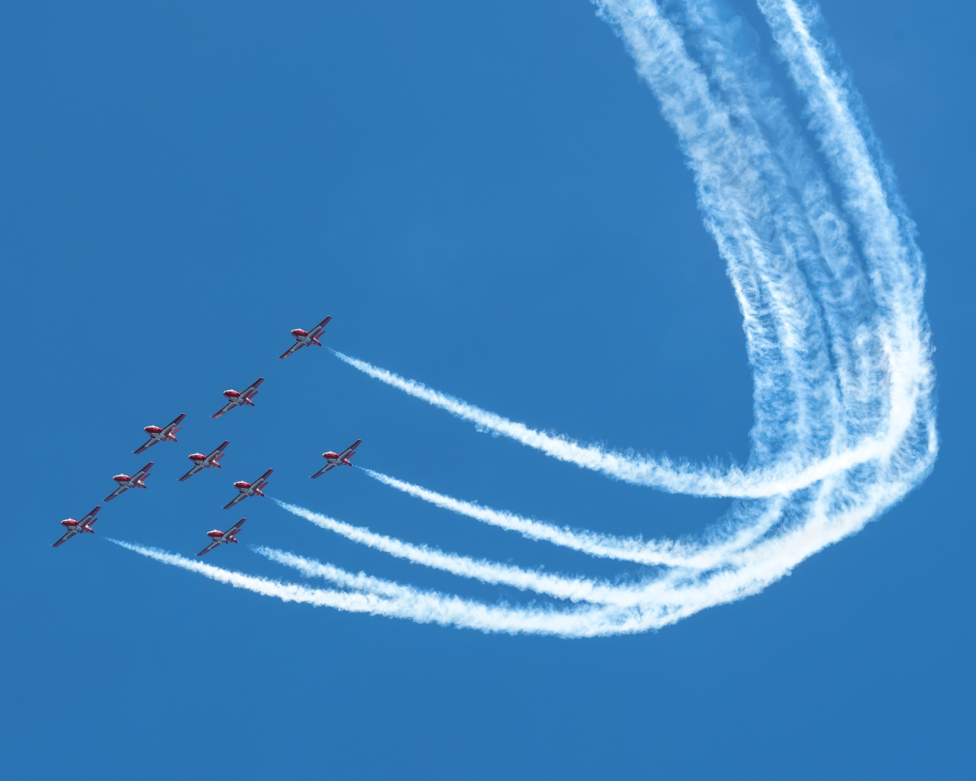 The Canadian Forces Snowbirds (431 Air Demonstration Squadron) perform a precision formation flight, leaving signature white smoke trails against a clear sky during their 2026 spring training demonstration over Vancouver Island. Fine art aviation photography by Kevin Prentice.