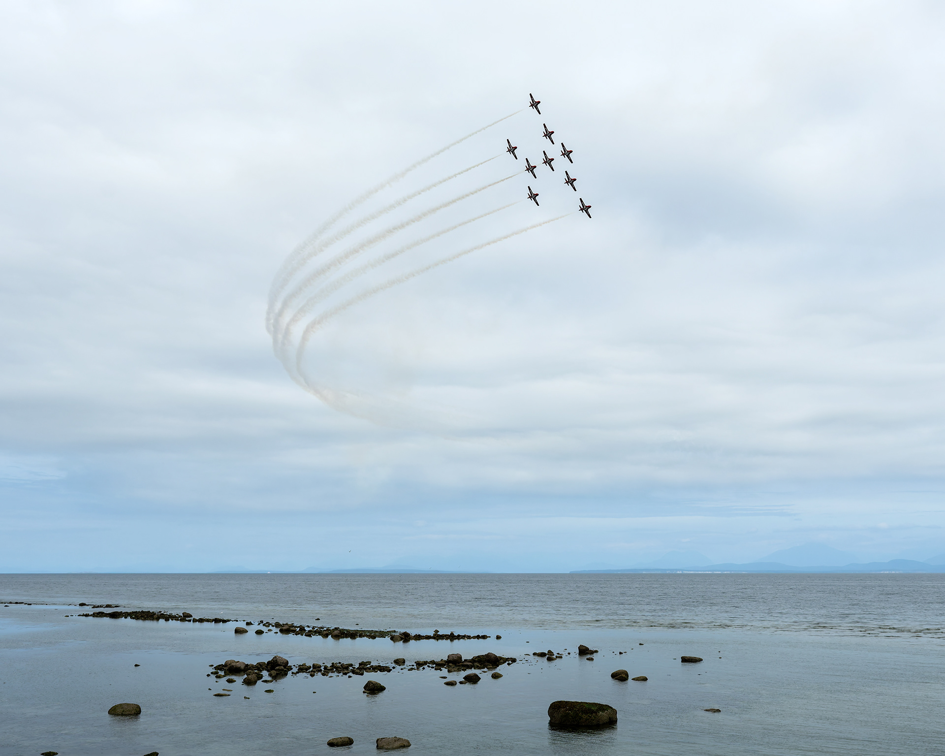 The Canadian Forces Snowbirds (431 Air Demonstration Squadron) perform a precision formation flight, leaving signature white smoke trails against a clear sky during their 2026 spring training demonstration over Vancouver Island. Fine art aviation photography by Kevin Prentice.