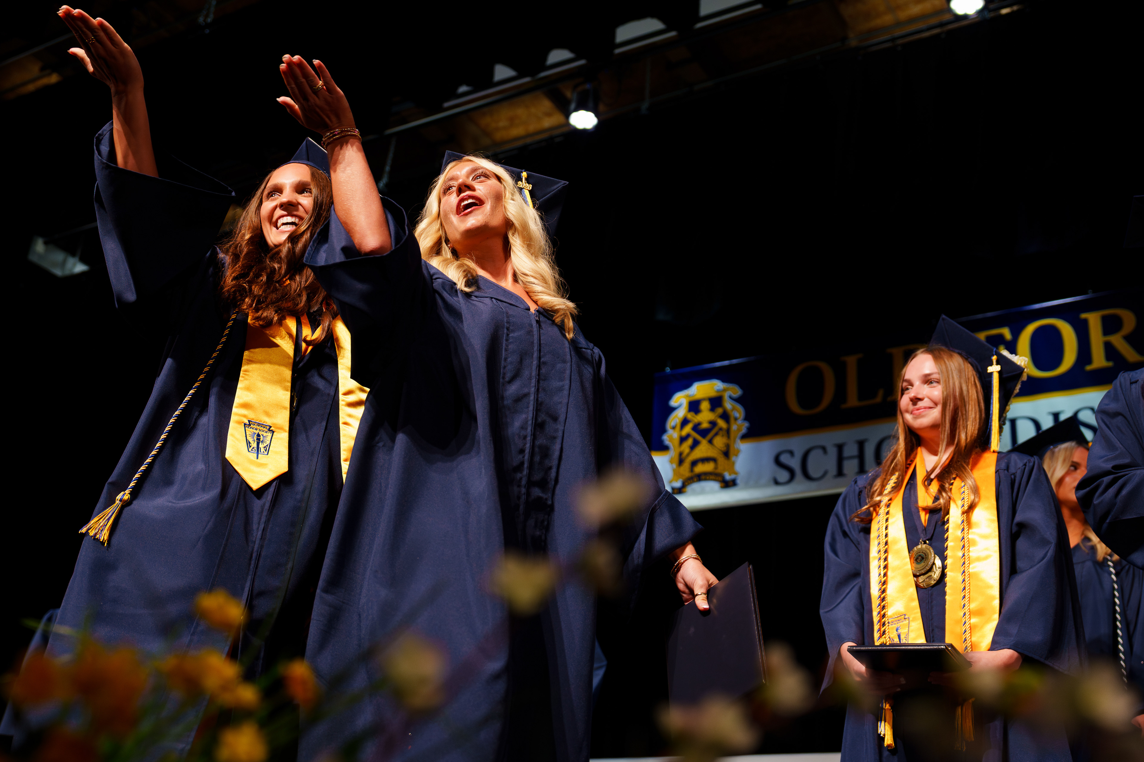 Two graduates blow kisses to the crowd as they leave the stage following the Old Forge High School graduation ceremony in Old Forge, Pa.