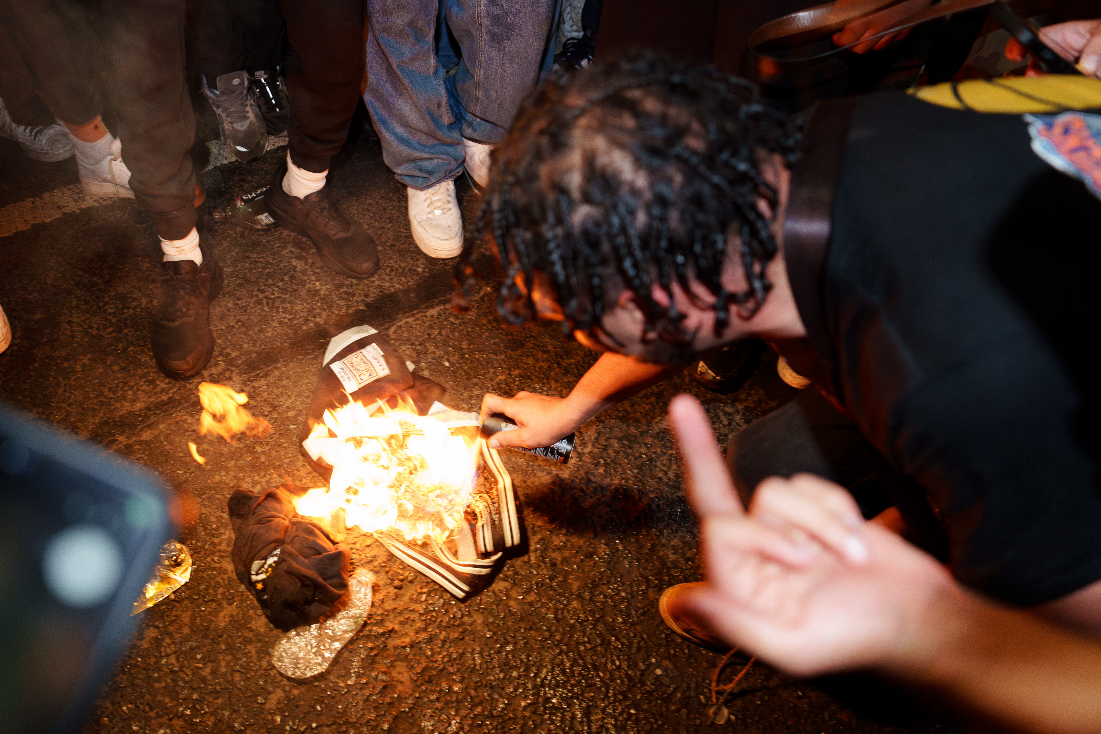 A New York Knicks fan pours lighter fluid onto a burning San Antonio Spurs jersey as crowds celebrate the team’s Game 4 victory in the NBA Finals in Manhattan.